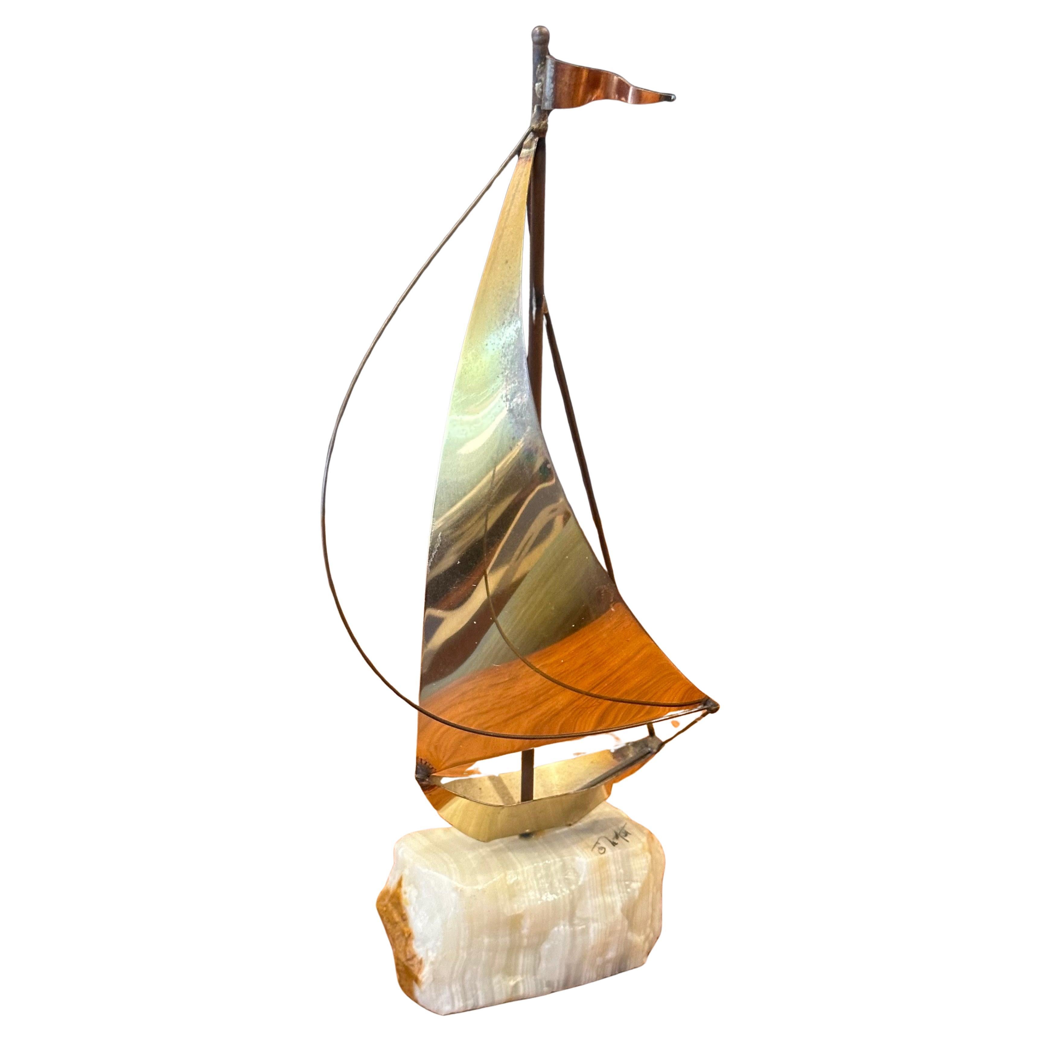 Una piccola scultura di barca a vela in ottone su base di quarzo di DeMoot, risalente agli anni '70 circa. La scultura è in buone condizioni vintage con una bella patina e misura 4 