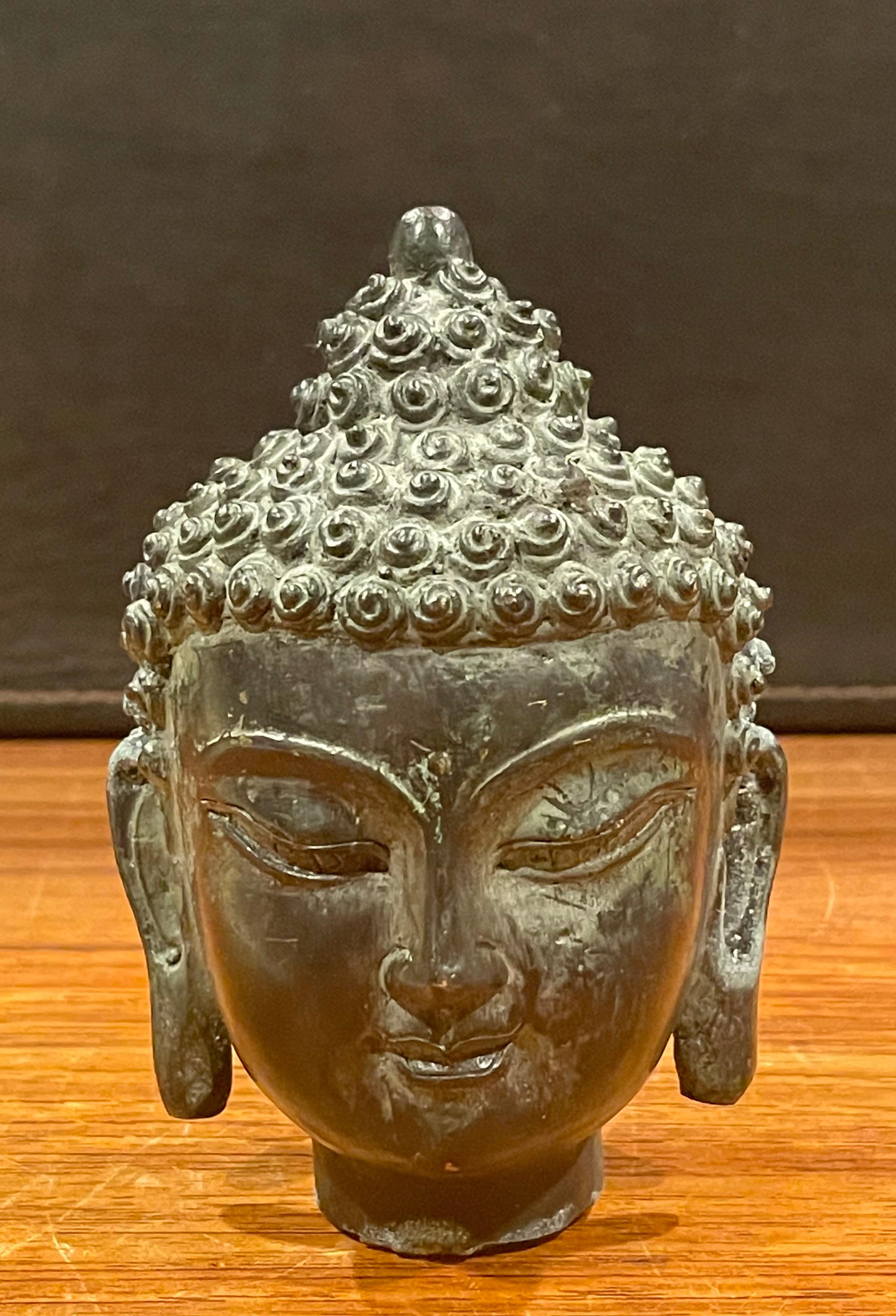 Small decorative cast bronze Buddha head, circa 1970s. The piece is in very good vintage condition and measures: 3.5