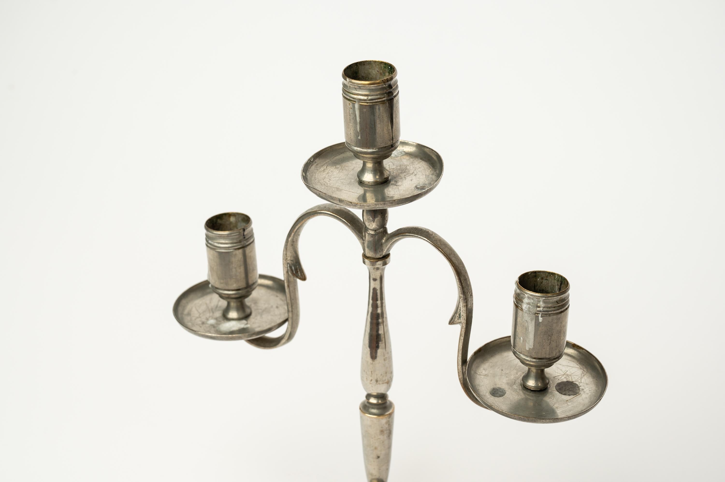 This small bronze candelabra is a classic design by Finnish architect and designer Paavo Tynell. It was made in Finland by Taito Oy in the 1920s or 1930s.

Tynell's candeholders are often decorated with simple geometric patterns or stylized flowers.