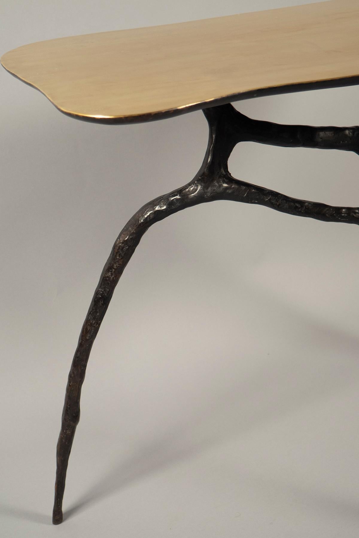 Black patinated bronze freeform base, supporting a polished bronze top.
  