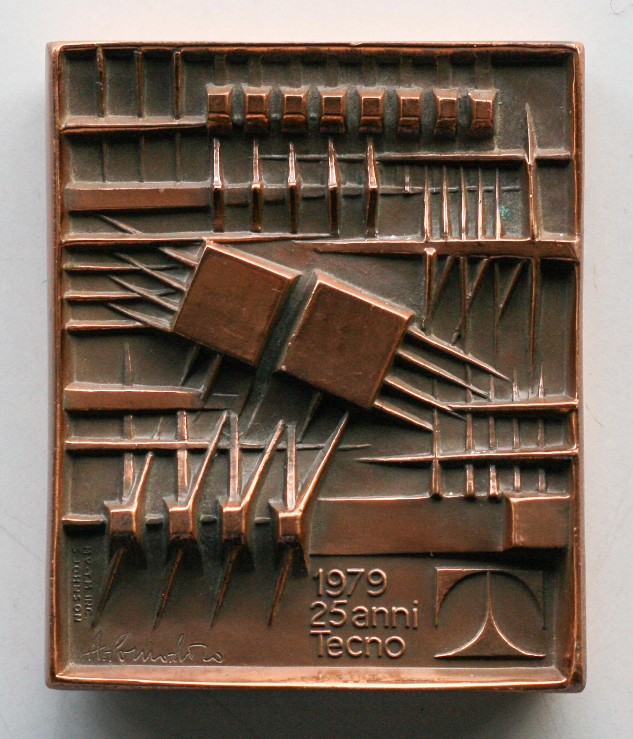 Arnaldo Pomodoro (born in 1926). 
Small plaque in bronze, with two-sided geometric image.
For the 25th anniversary of Tecno Milan, dated 1979. 
Incised signature A. Pomodoro and stamped S. Johnson, numbered 12/B.
Issued by Stefano Johnson of Milan.