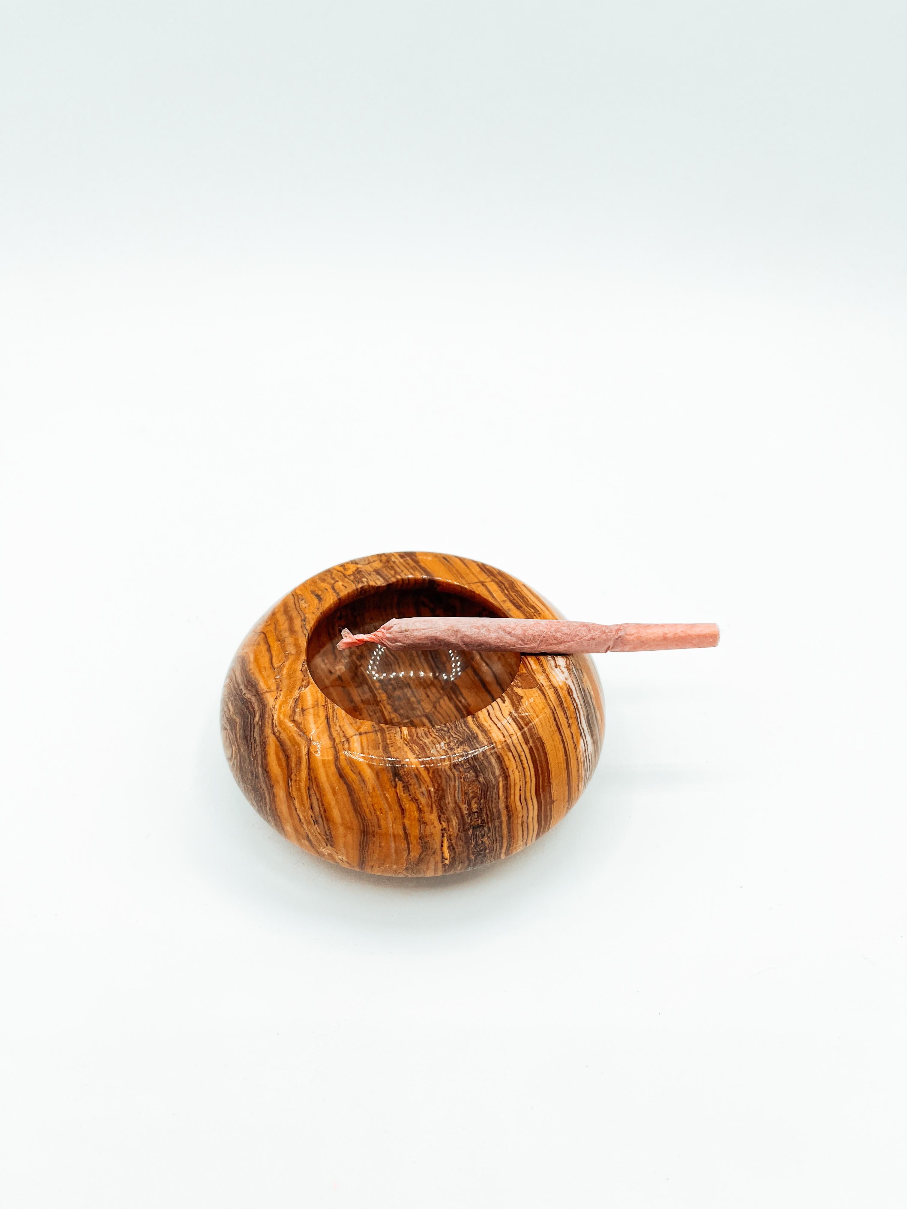 This vintage mid-century ashtray showcases the natural beauty of brown and orange marble onyx, featuring striking swirls and layered veining that add depth and character. Its smooth, polished finish highlights the organic patterns, making it a