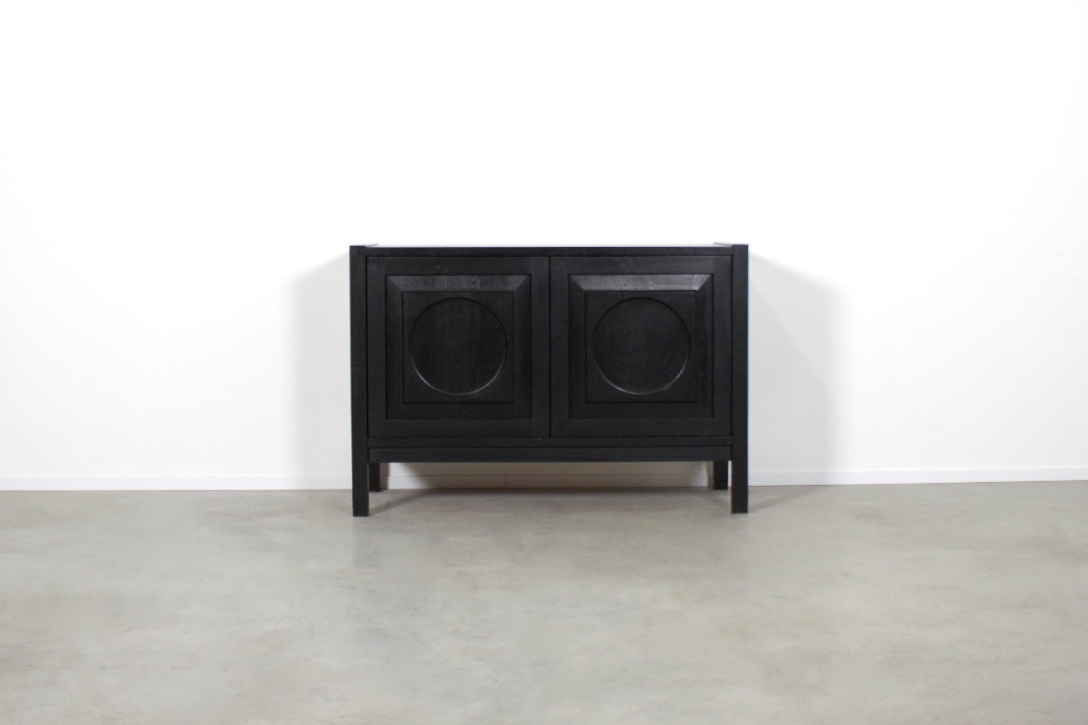 Black brutalist sideboard in very good condition. 

Made in Belgium in the 1970s 

This sideboard has two doors made of massive black stained oak, each with a three-dimensional pattern. 

The sideboard has beautiful visible joints on each corner of