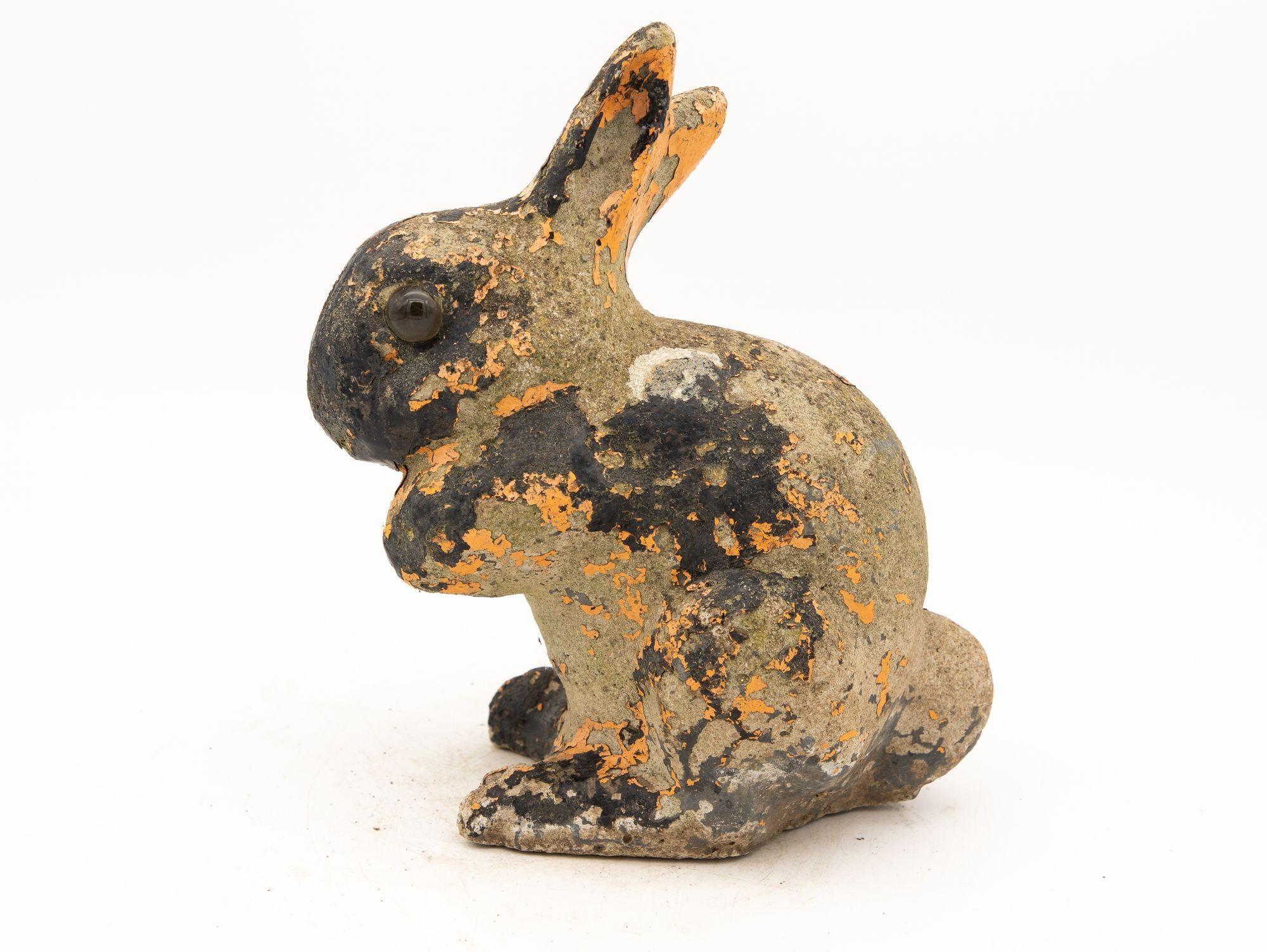 This charming garden ornament takes the shape of an adorable sitting bunny molded from durable concrete. With a touch of whimsy and a hint of nostalgia, this bunny carries a sense of character and history. The weathered exterior reveals hints of its