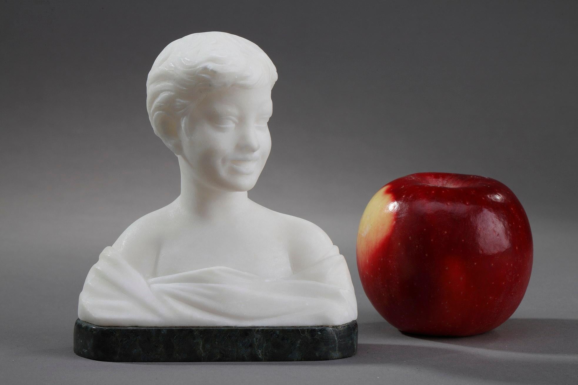 Small alabaster bust representing a young boy wearing a drape. This very lively statuette shows him talking while turning to the left. This fine sculpture individualizes the child's hair strands. The whole rests on an oval base in green marble.