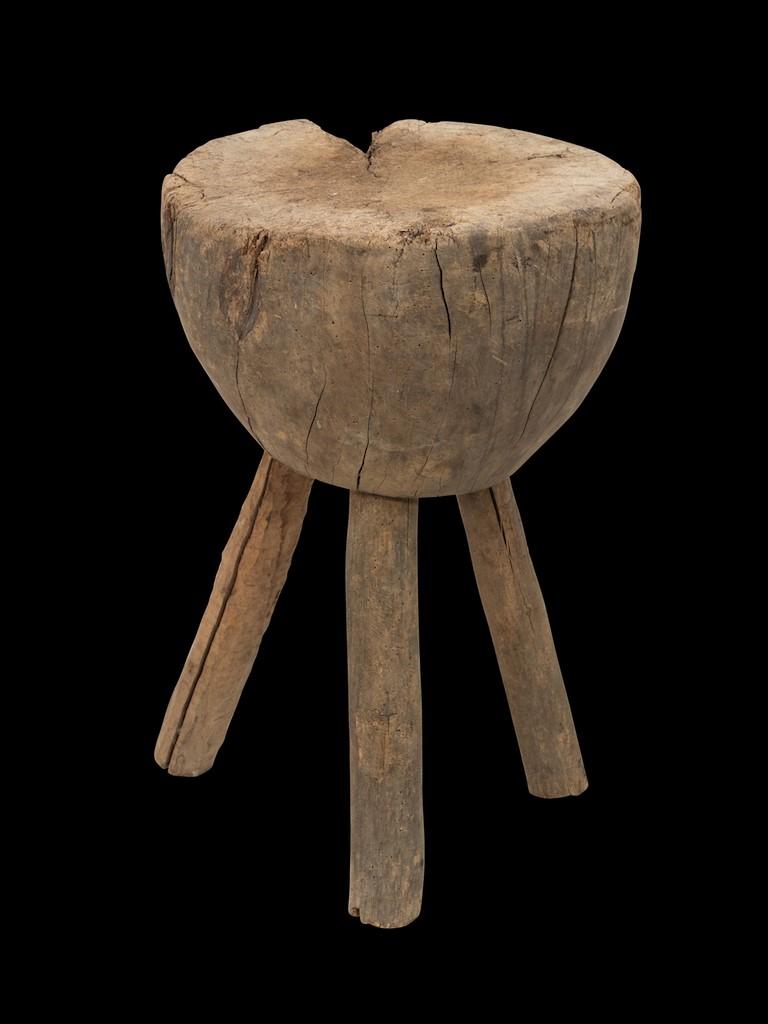 Rustic, antique three-legged butcher's block originating from France. Made in the 19th century, this rustic antique has a beautiful age and honest patina. Solid walnut carved into a unique semisphere shape and supported by three legs. At its petite