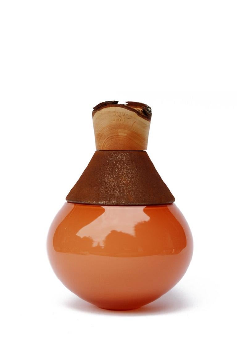 Small candy apricot India vessel II, Pia Wüstenberg.
Dimensions: D 18 x H 25.
Materials: glass, wood, metal.
Available in other metals: brass, copper, aluminum, rust.

Handmade in Europe, by individual craftsmen: handblown glass (Czech