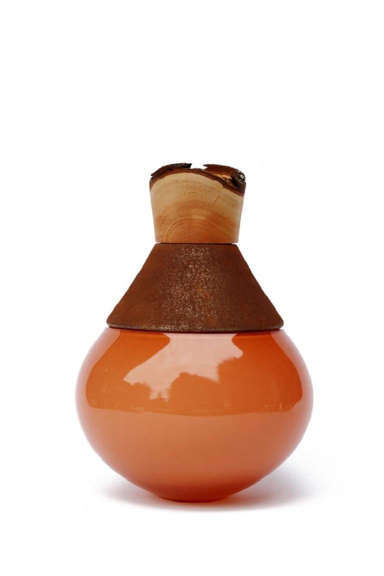 Vaso India II, Pia Wüstenberg.
Dimensioni: D. 18 x H. 25.
Materiali: vetro, legno, metallo.
Disponibile in altri metalli: ottone, rame, alluminio, ruggine.

Realizzato a mano in Europa, da singoli artigiani: vetro soffiato a mano (Repubblica