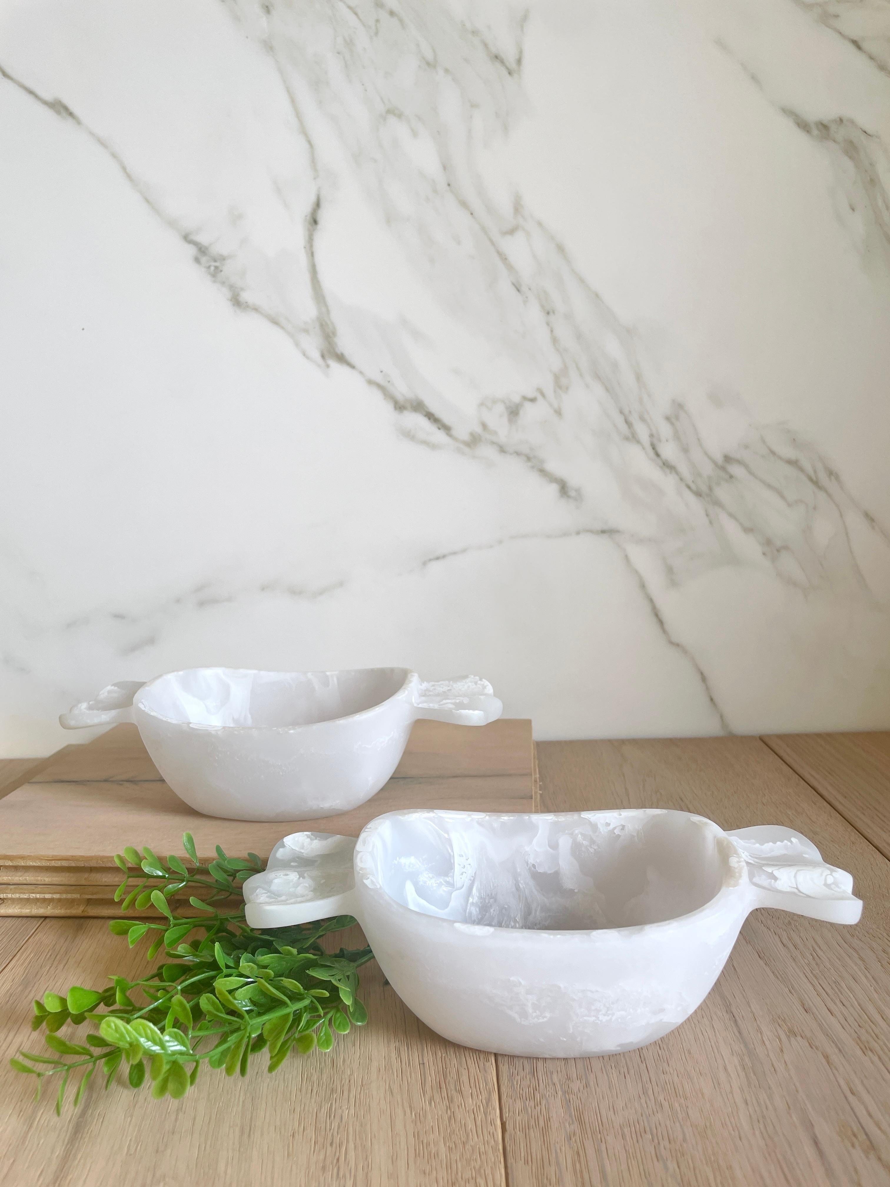 La nostra Candy Bowl è realizzata a mano in resina bianca traslucida con texture marmorizzata in bianco e perla. È simpatico e divertente e rappresenta un pezzo forte che può essere utilizzato per servire le tue caramelle preferite o come accento
