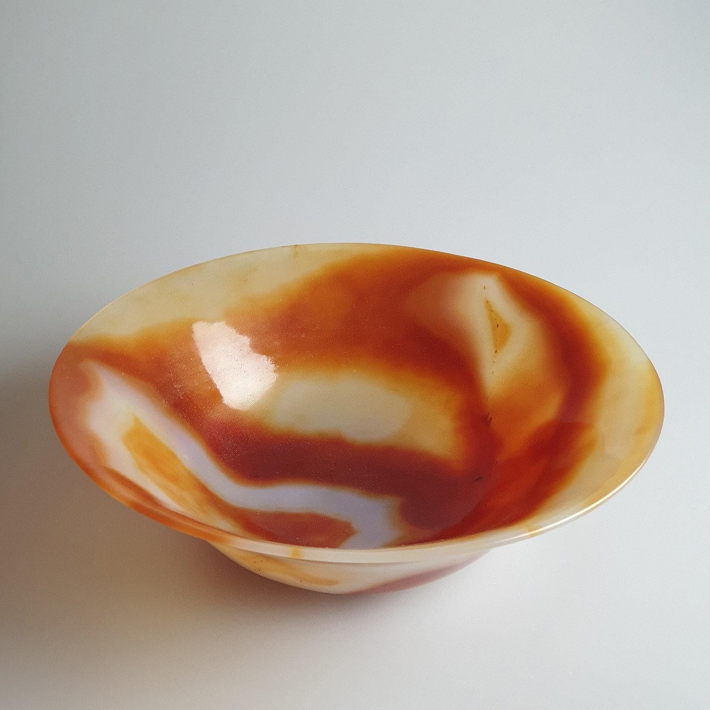 Exquisitely manufactured from a single piece of the Brazilian carnelian agate, this bowl is a one-of-a-kind object. Creating various shades of colors ranging from a dark red to blending tones of white and orange completing the bowl's rim, it