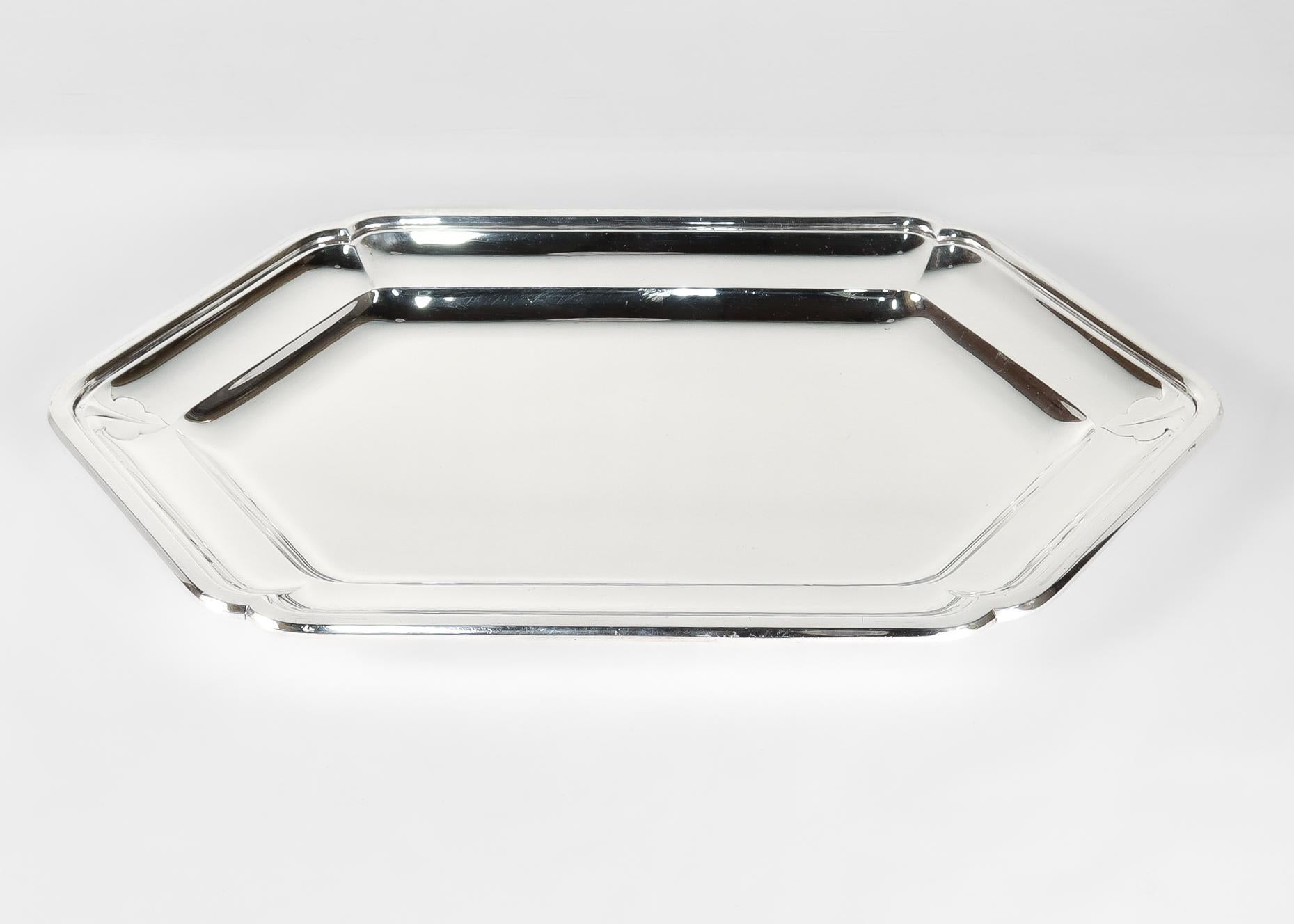 Un vassoio o piatto da portata in stile Art Déco francese molto raffinato.

In argento fine 950. 

Di forma esagonale o a sei lati, con bordo sagomato, bordo a gradini e pozzetto poco profondo.

Decorato con una foglia stilizzata in rilievo