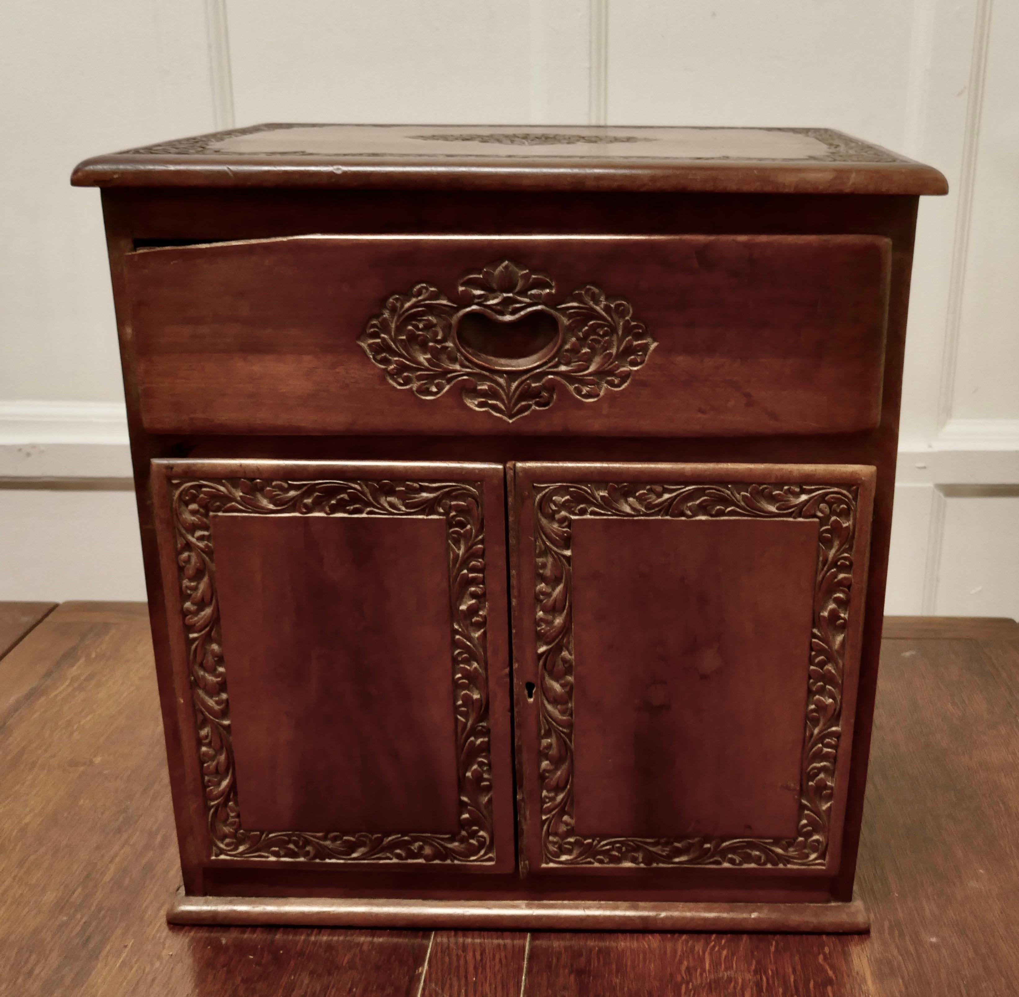 Small Carved Cupboard with Drawer 

A Charming little piece made in Teak, the cabinet has a 2 door cupboard with along drawer above
A charming craftsman made piece showing the skill of the carver with detailed decoration on all sides
This piece