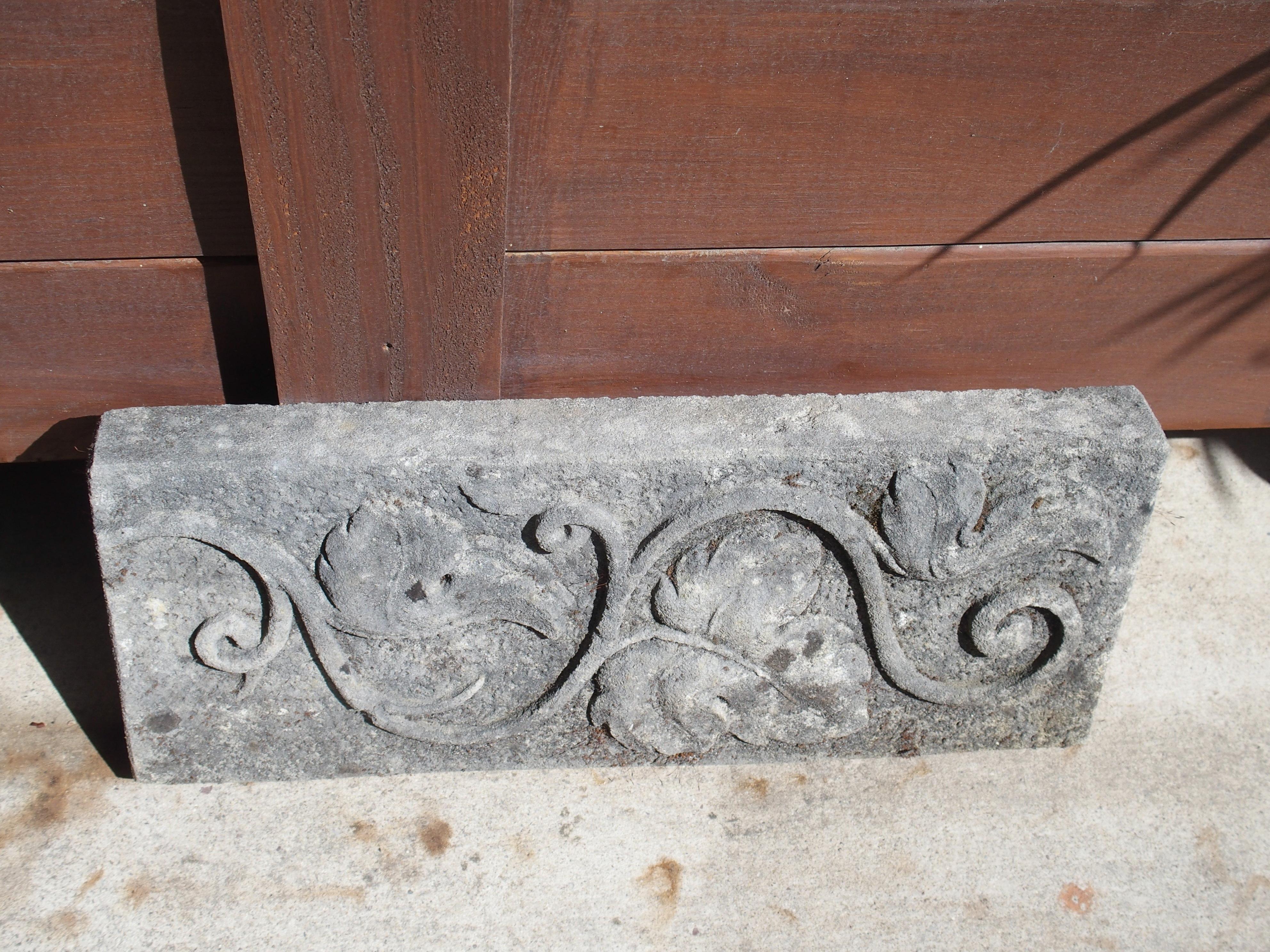 From Italy, this small limestone plaque depicts a hand-carved twisting vine with three large leaves in bas relief. Presented horizontally, the vine meanders the entire length of the rectangular plaque. The gray limestone has developed a wonderful,
