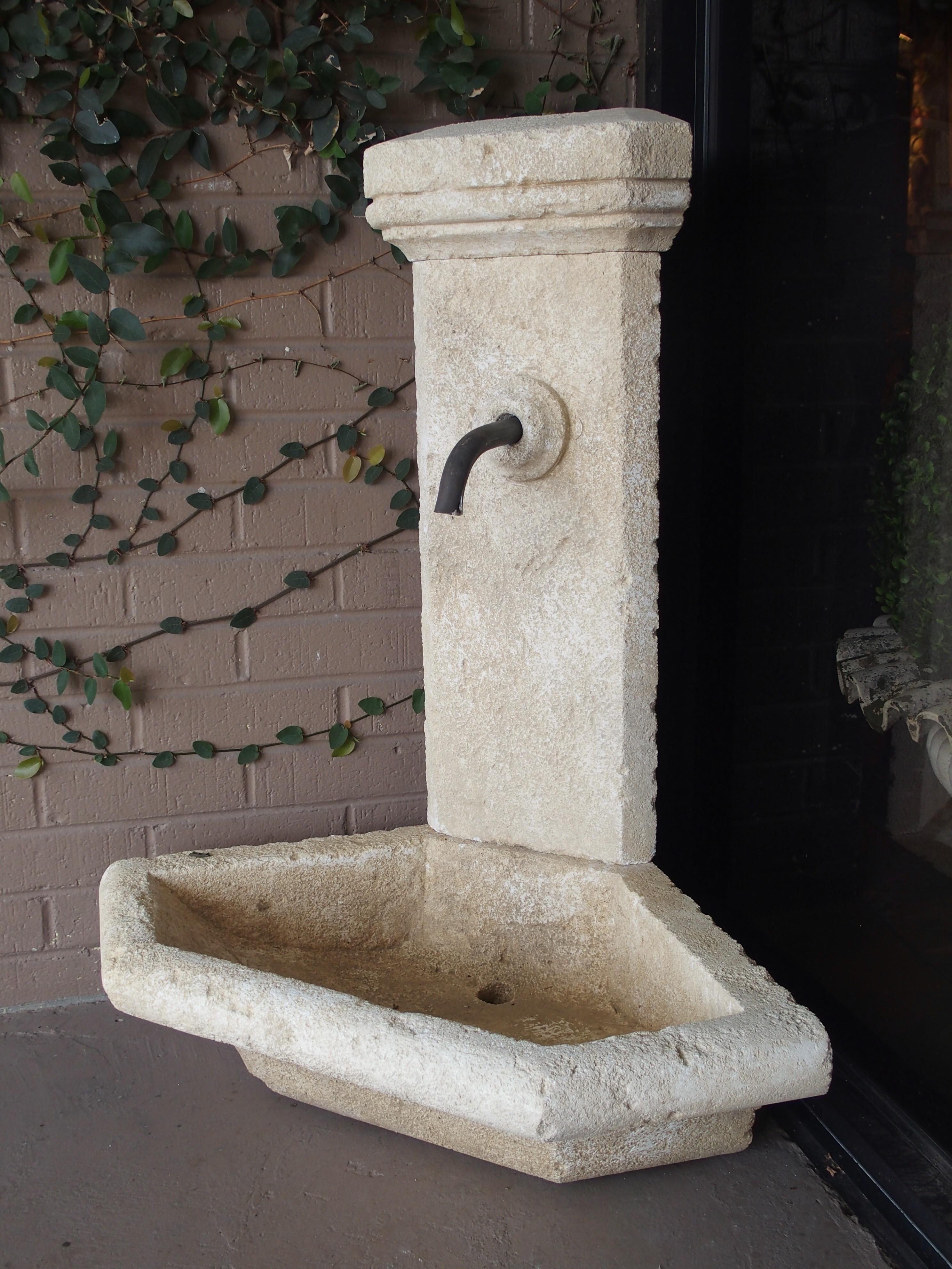 This charming hand carved corner fountain from the South of France is made from Estaillade limestone. The stone has a soft natural color patina added in addition to distressed markings. This fountain is quite unique in that it can be free-standing