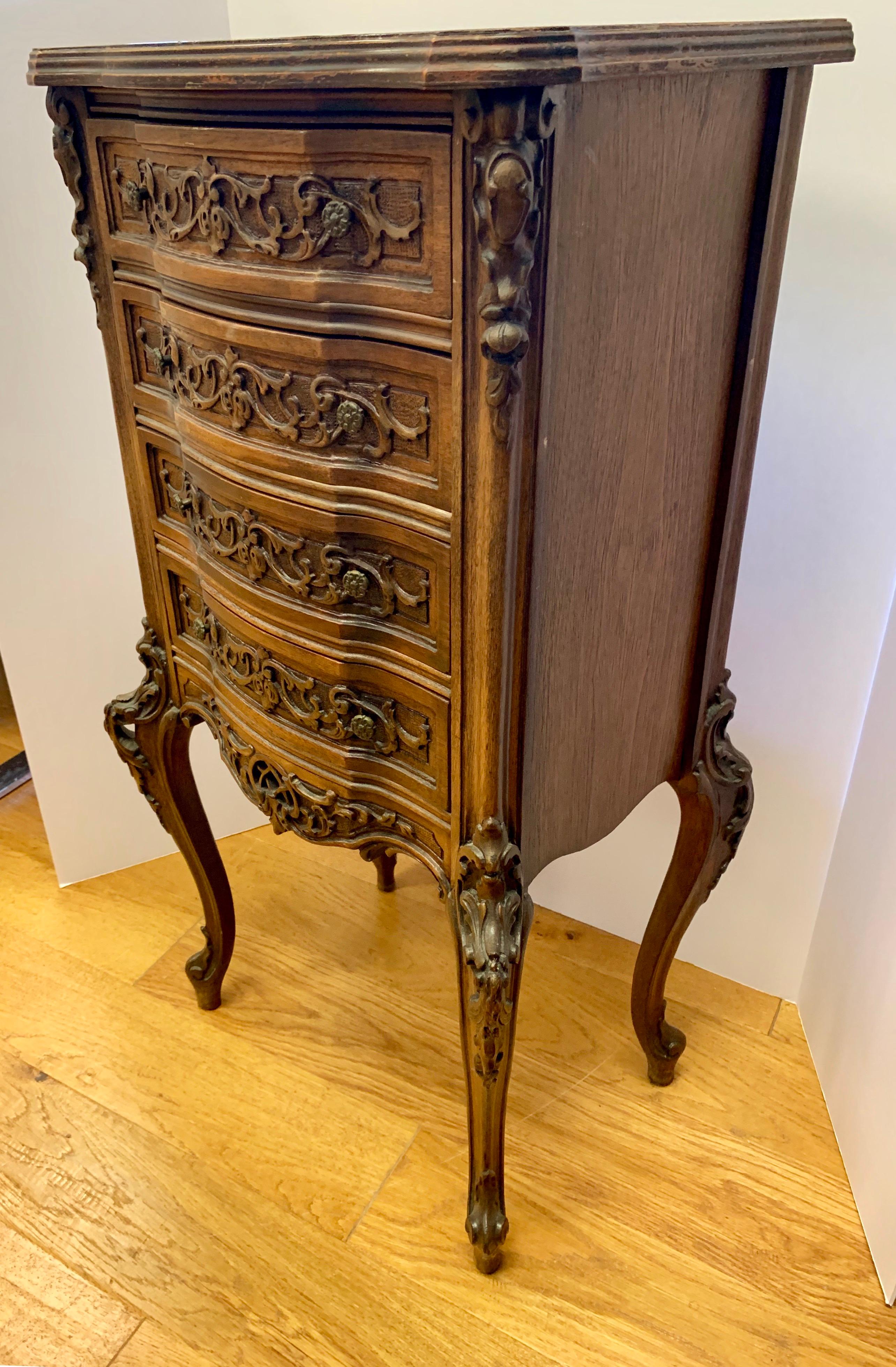 Elegant mahogany four drawer chest of drawers with intricate carvings throughout.