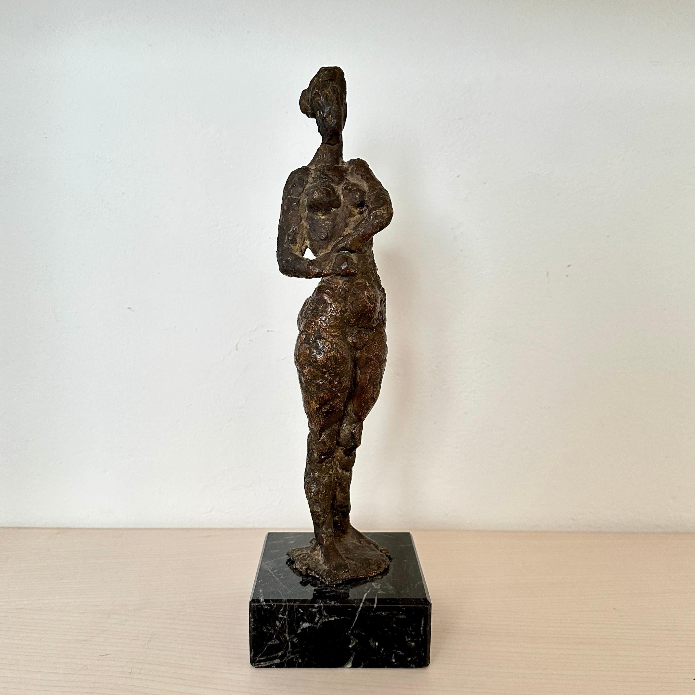 Créée en 1969 par le célèbre artiste Oskar Bottoli, cette petite sculpture en bronze moulé capture l'allure intemporelle de la forme féminine. 
Représentant une femme nue debout, l'œuvre dégage un équilibre délicat entre la grâce et la force.