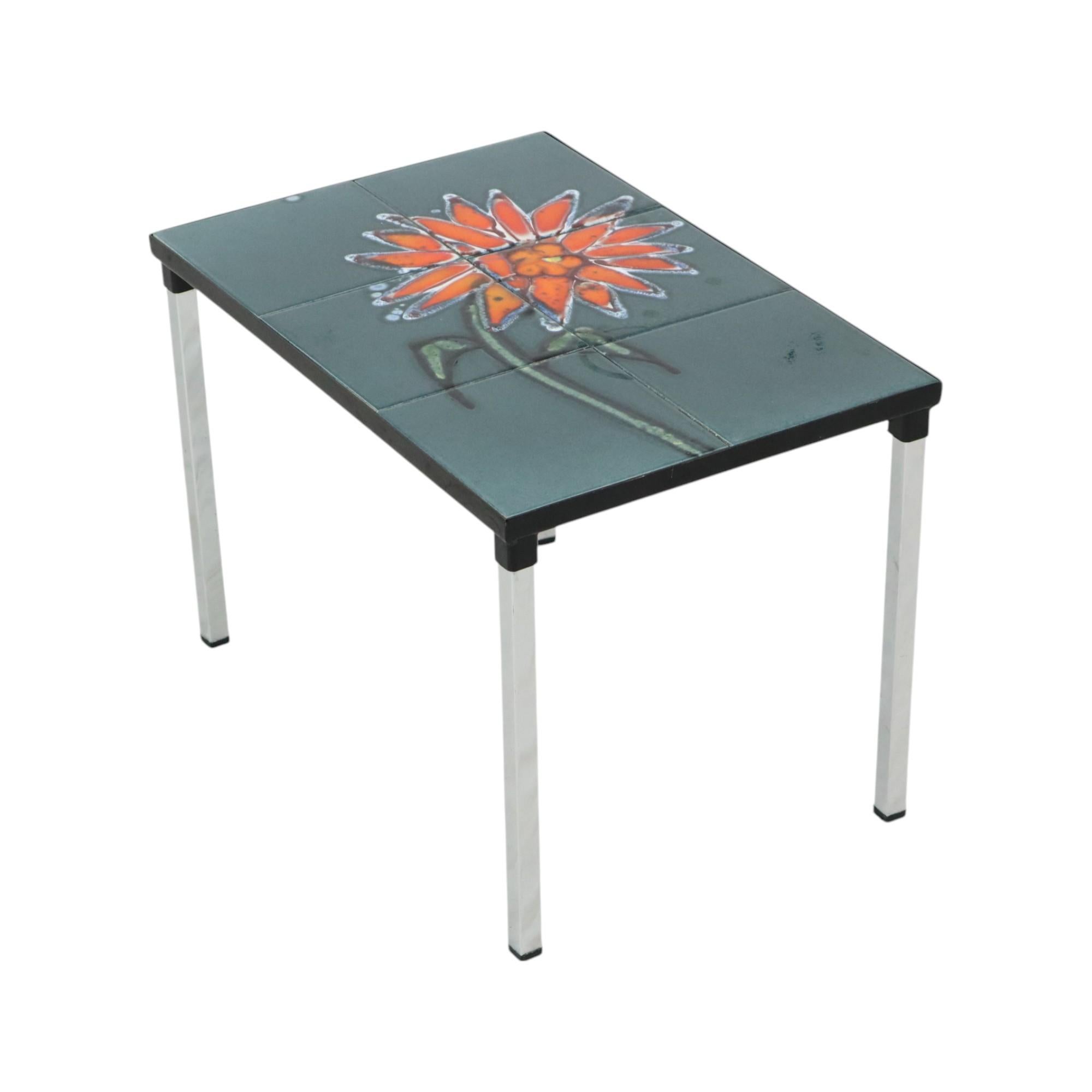 Petite table vintage en céramique, table d'appoint avec 6 carreaux émaillés et une fleur abstraite orange avec tige, par Juliette Belarti pour ADRI, design des années 60, Belgique.

Magnifique table avec un tableau en guise de plateau, les carreaux
