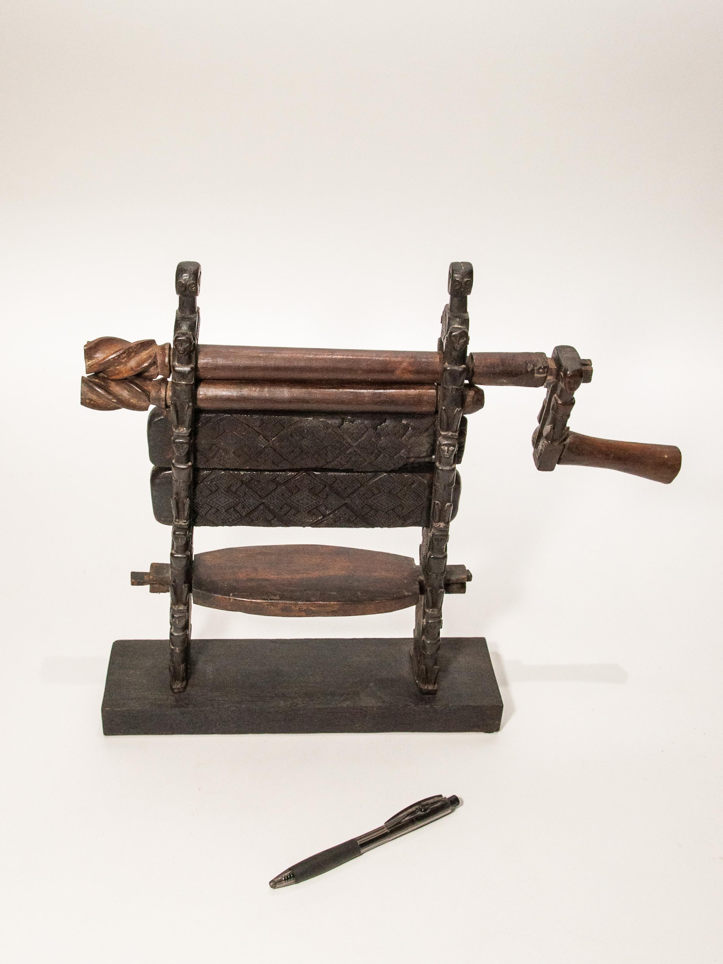 Small carved ceremonial cotton gin from the Atoni of West Timor. Mid-late 20th century, set on a wooden stand for stability and display.
This is a relatively small scale hand carved example of a cotton gin, called a bninis in the Atoni language, of
