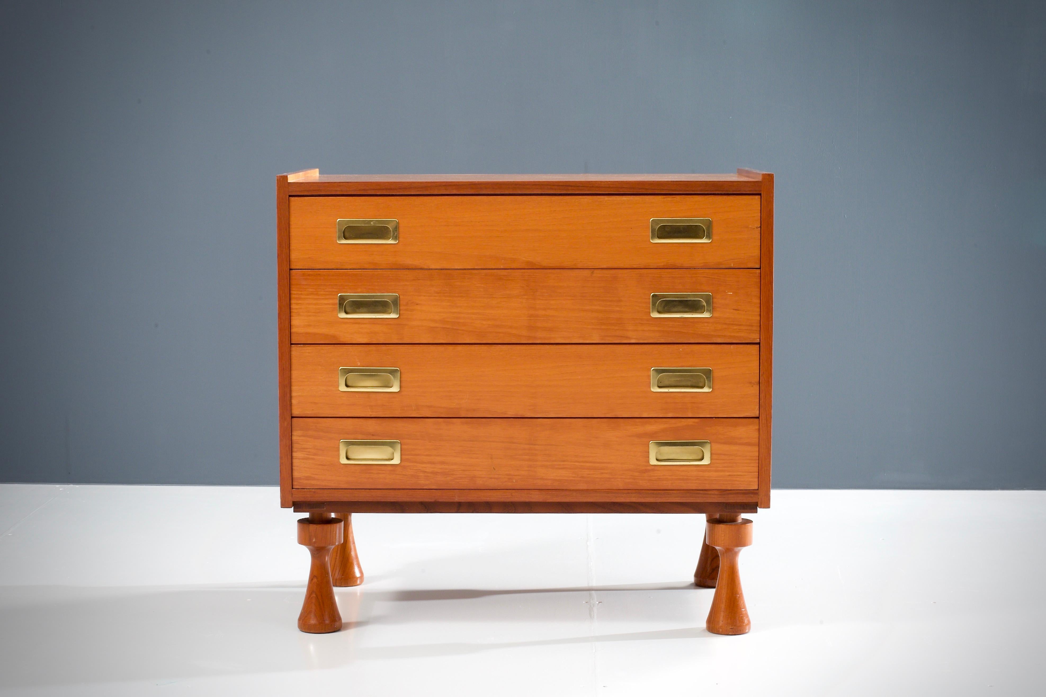 Geometrical four-drawer chest in walnut and brass. It's definitely the solid legs that make this chest so interesting. Their geometrical shape is very well proportioned and a good balance against the straight lines of the rest of this sideboard, a