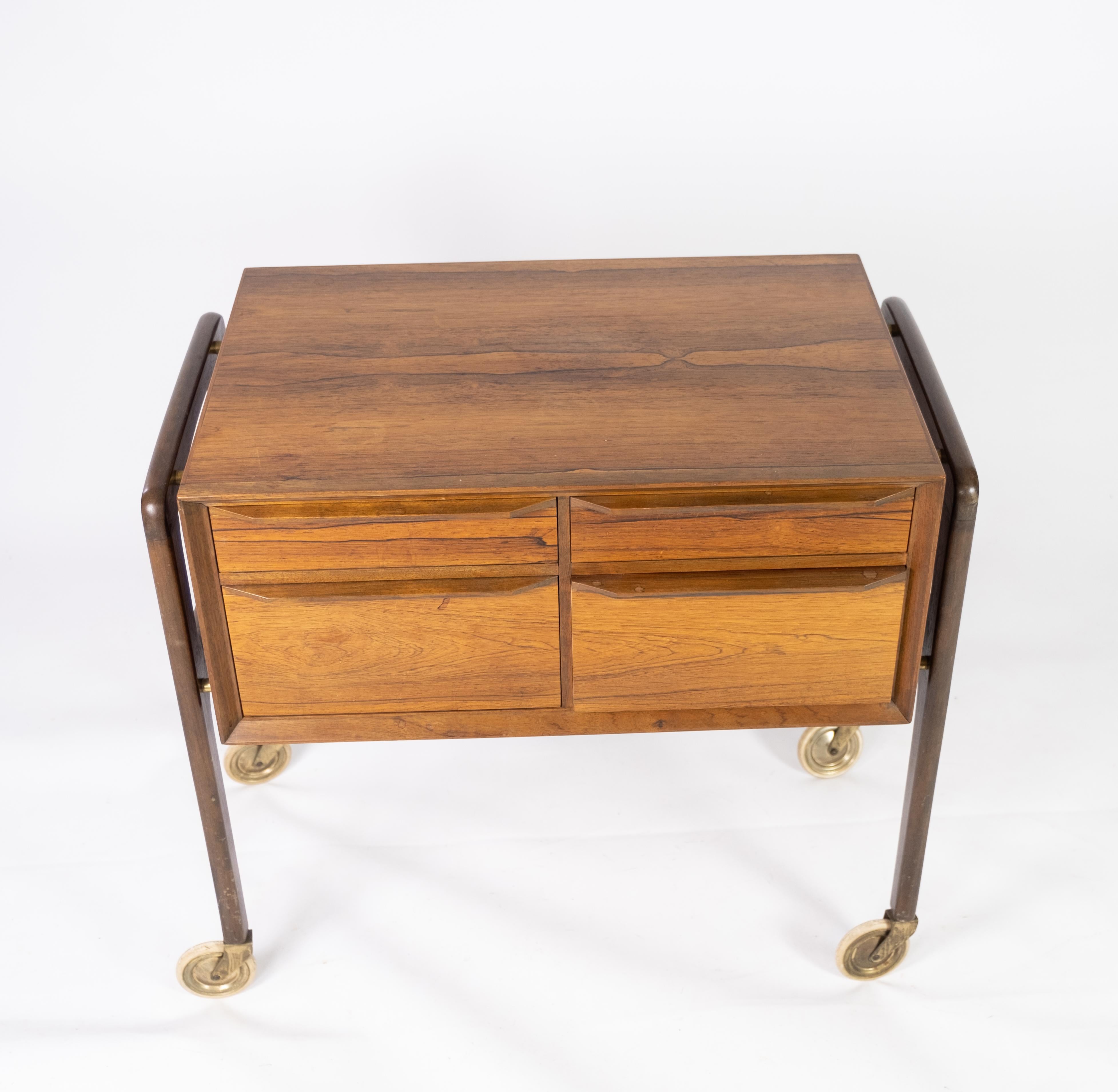 
This small chest of drawers on wheels epitomizes the elegance and functionality of Danish design from the 1960s. Crafted from luxurious rosewood, renowned for its rich color and distinctive grain patterns, this piece exudes sophistication and