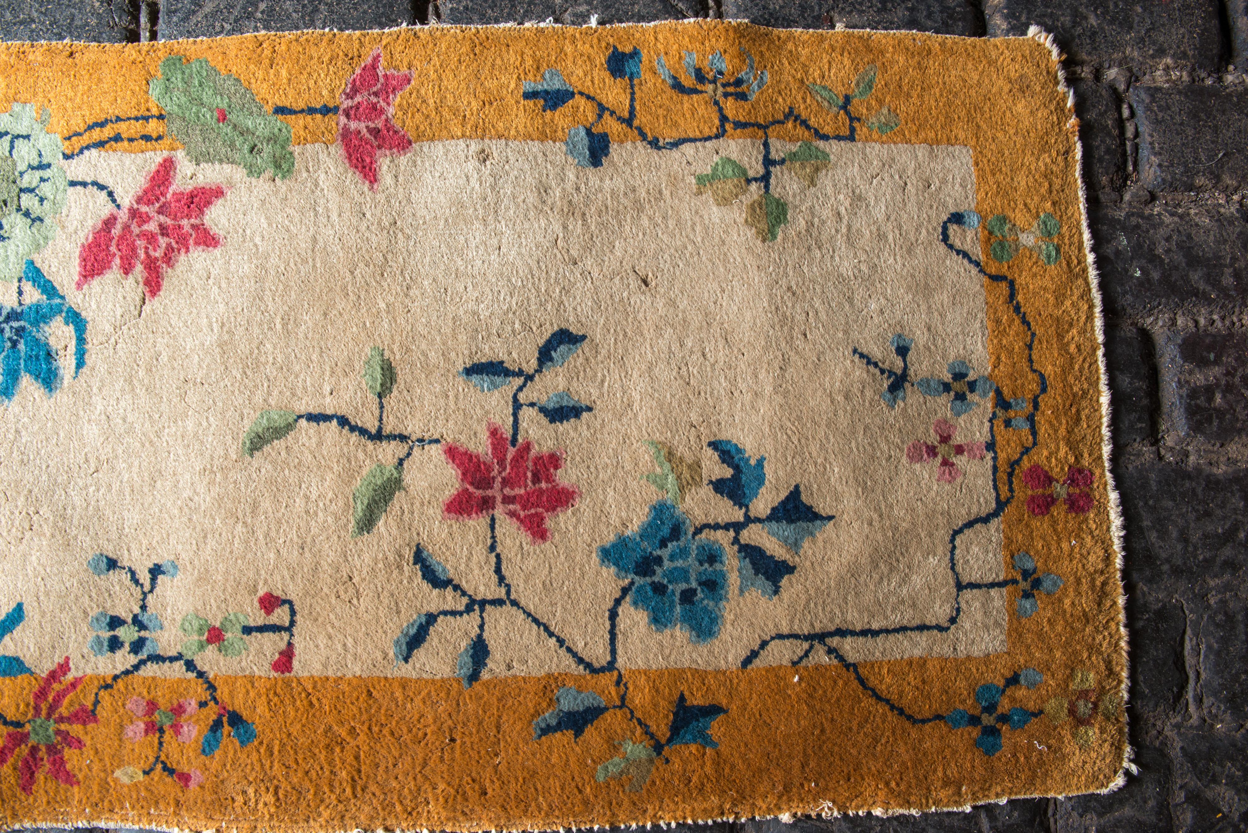 Small Chinese Art Deco wool rug with a deep yellow-gold border, beige field with multi-color decorative features.