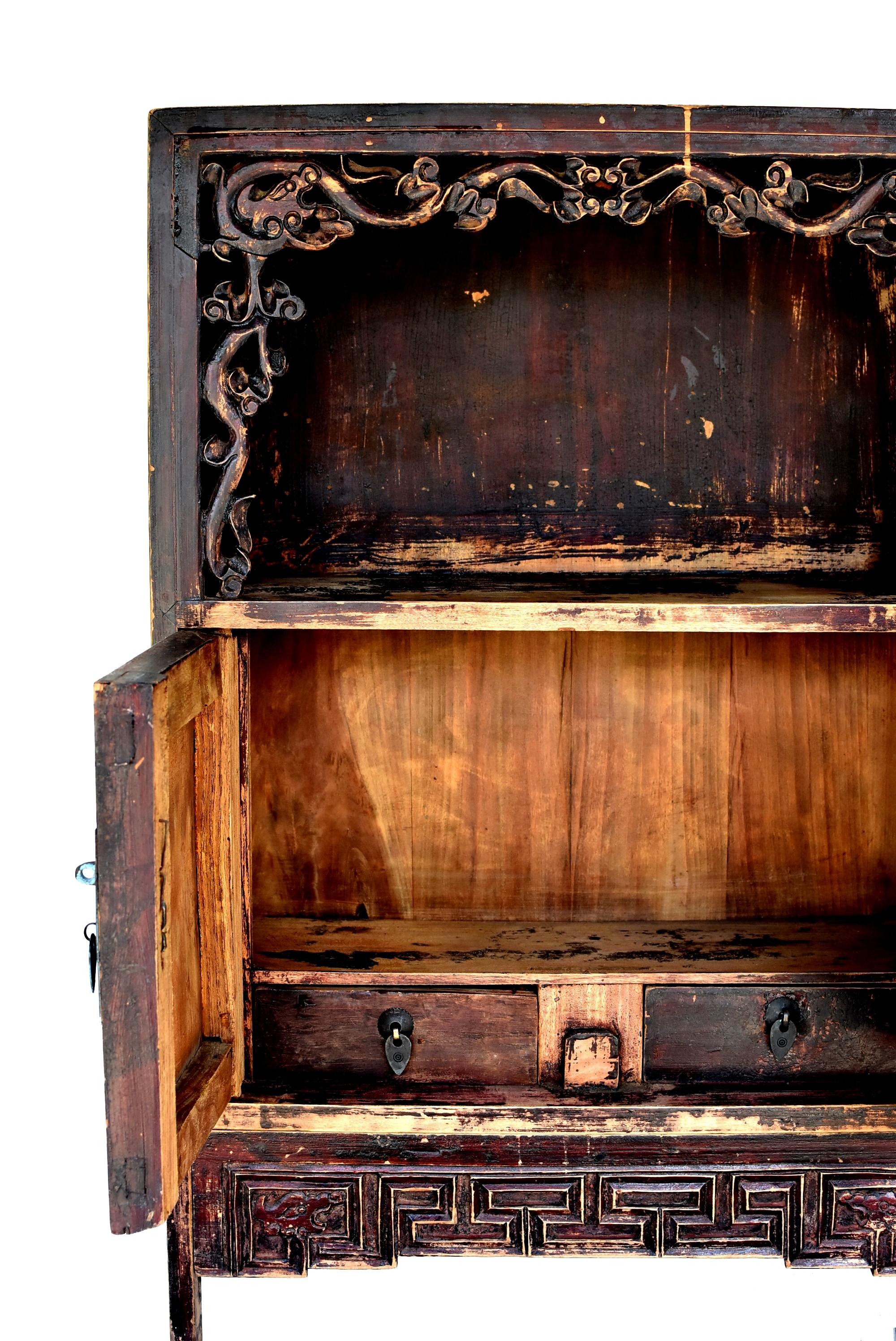 A beautiful small antique chest from northern China. Open feature has a carved dragon framework that is delicate and fluid. Such an open shelf is favored by the region of Shan Dong and Shan Xi. Interior space and two drawers for extra storage. All