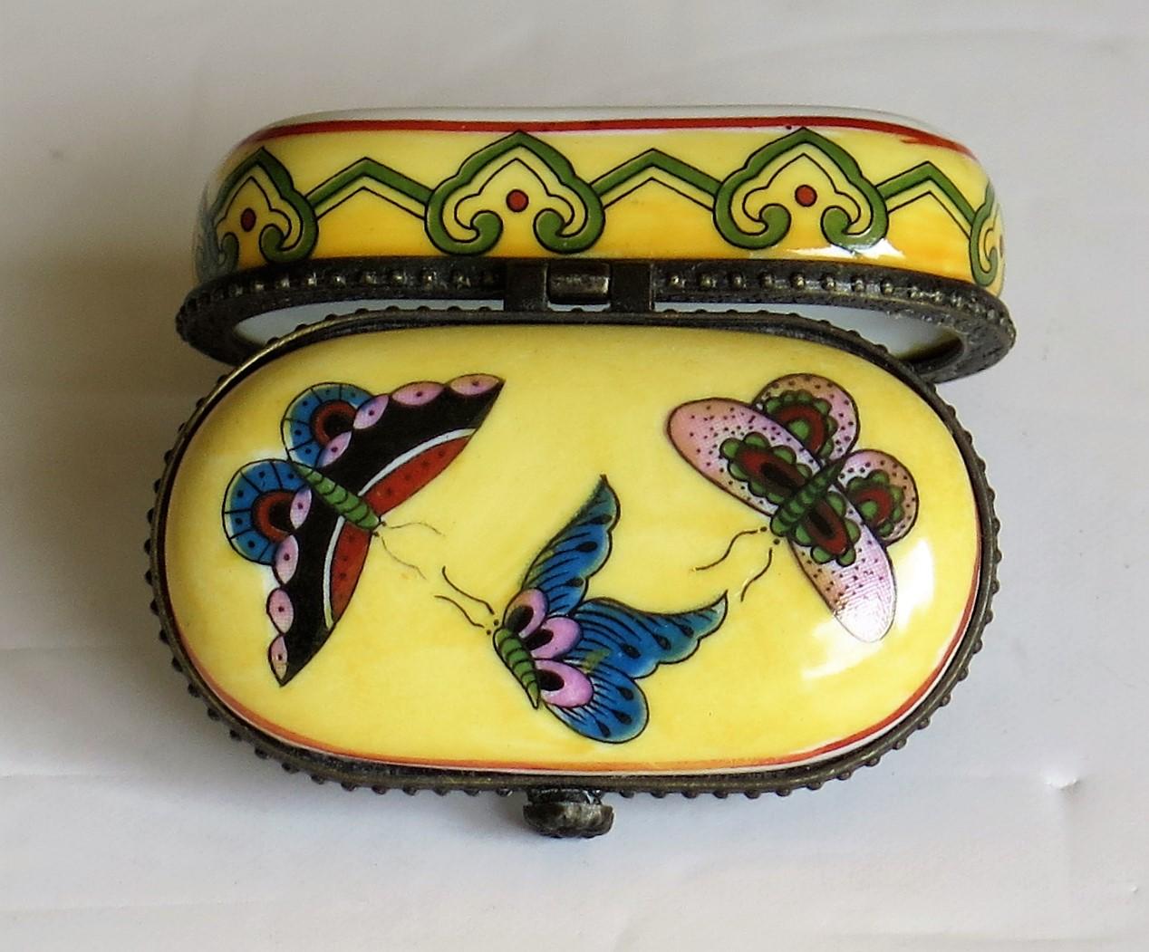 This is a small Chinese Export porcelain decorative box with a hinged lid and hand painted decoration of butterflies on a yellow ground, which we date to the mid-20th century, circa 1950.

The box is rectangular in shape with rounded corners. The