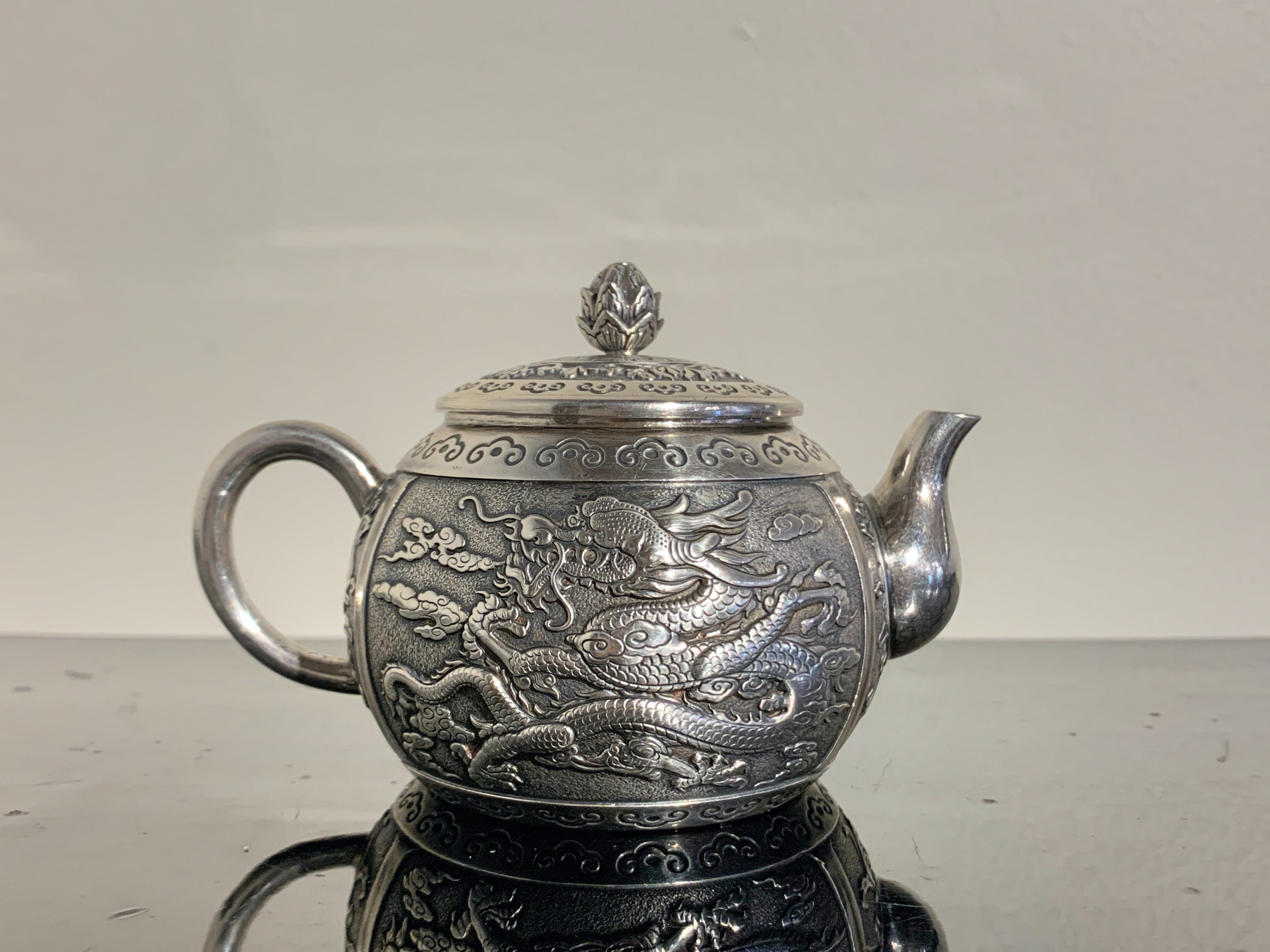 A fine and heavy diminutive Chinese export silver dragon teapot, by Wang Hing & Co, late 19th century, China. 

The small teapot, of traditional form, is finely crafted from a high quality silver, slightly higher than sterling. 
The globular body