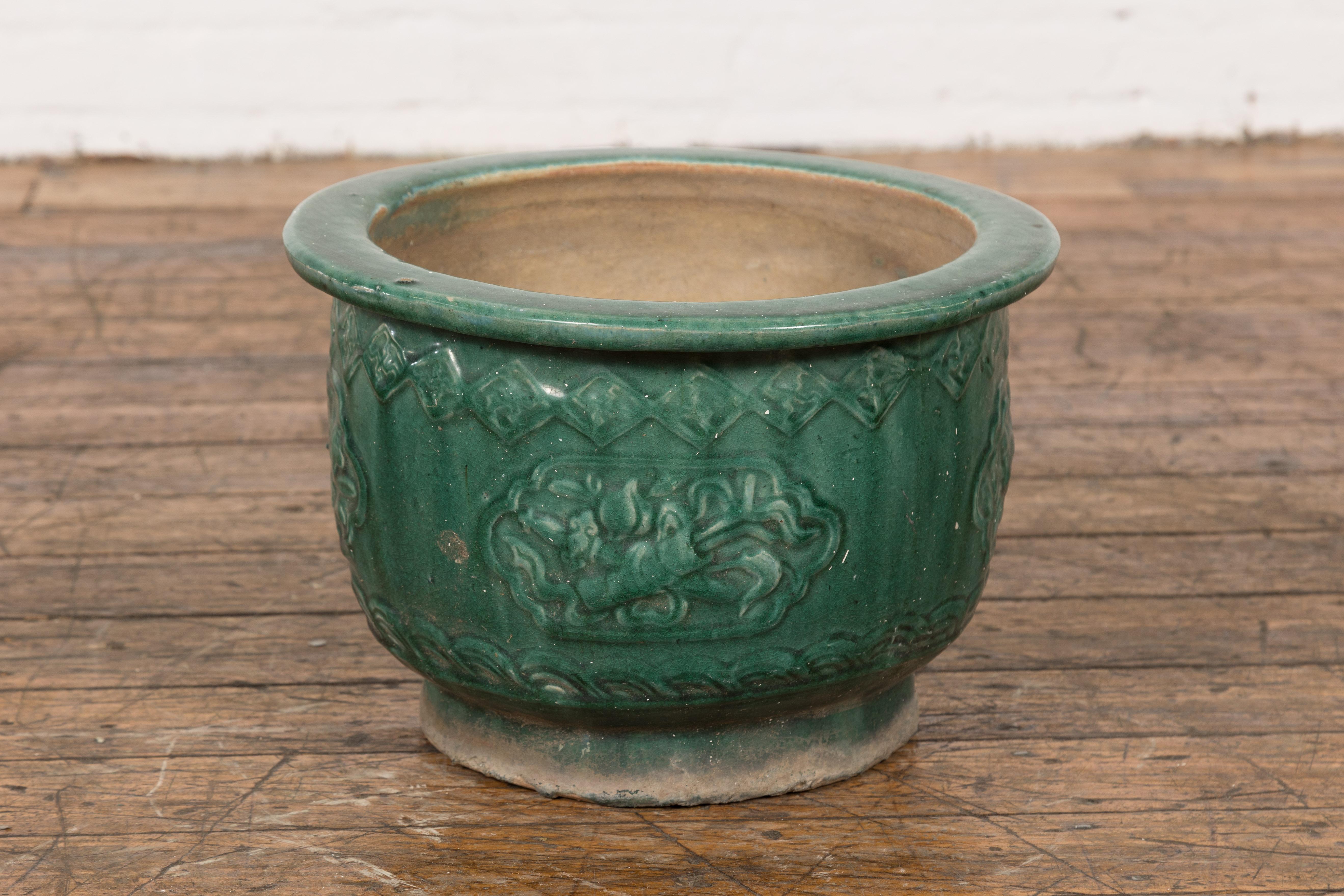 A small Chinese Qing Dynasty period Hunan style green glaze planter from the 19th century with raised cartouches surrounding objects, flowers and foliage. This charming small Chinese Qing Dynasty period Hunan style green glaze planter from the 19th