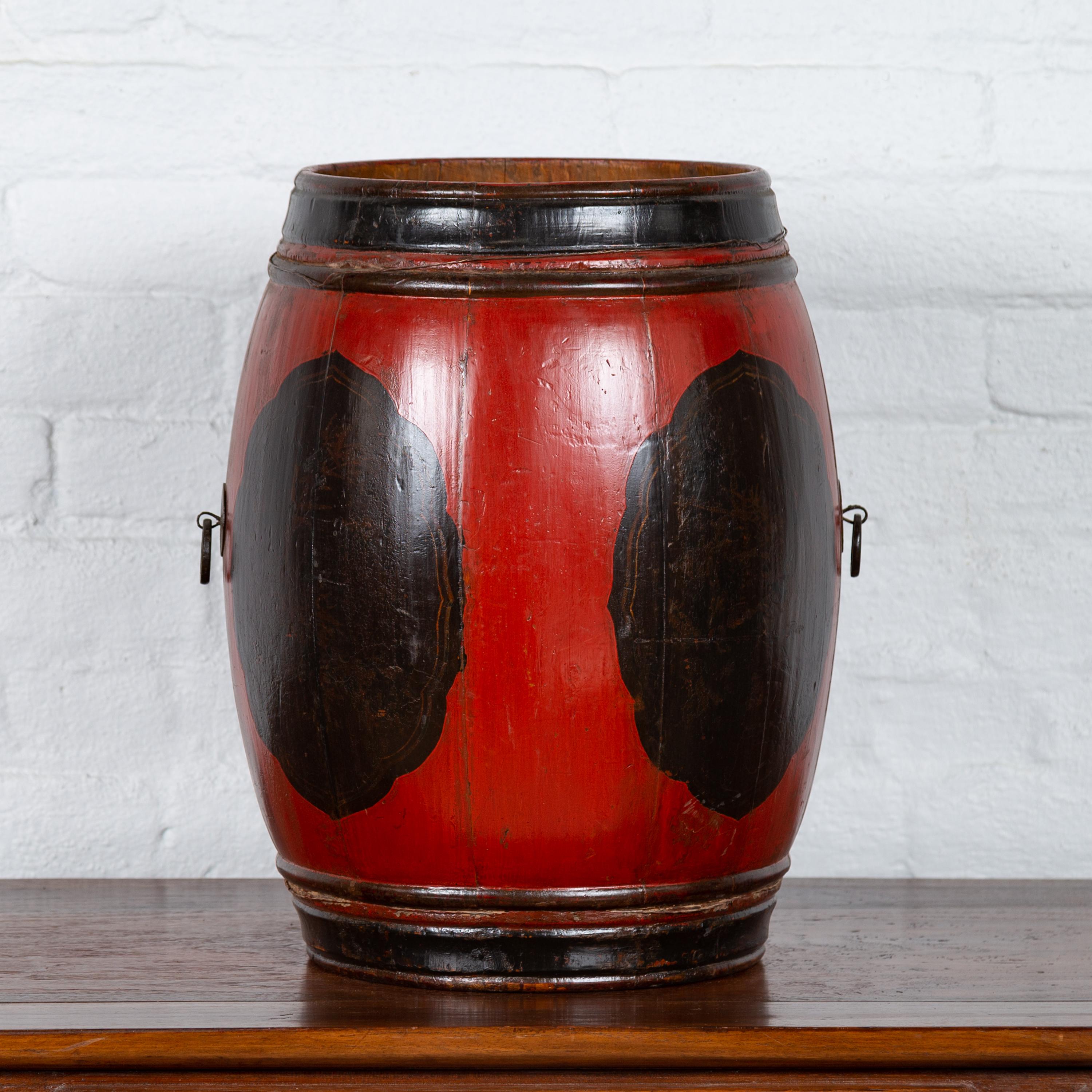 A small vintage Chinese wooden barrel planter from the mid-20th century with red and black lacquer. Born in China during the mid-century period, this small barrel presents a nice contrast of colors. The black molded edges of the top and bottom frame