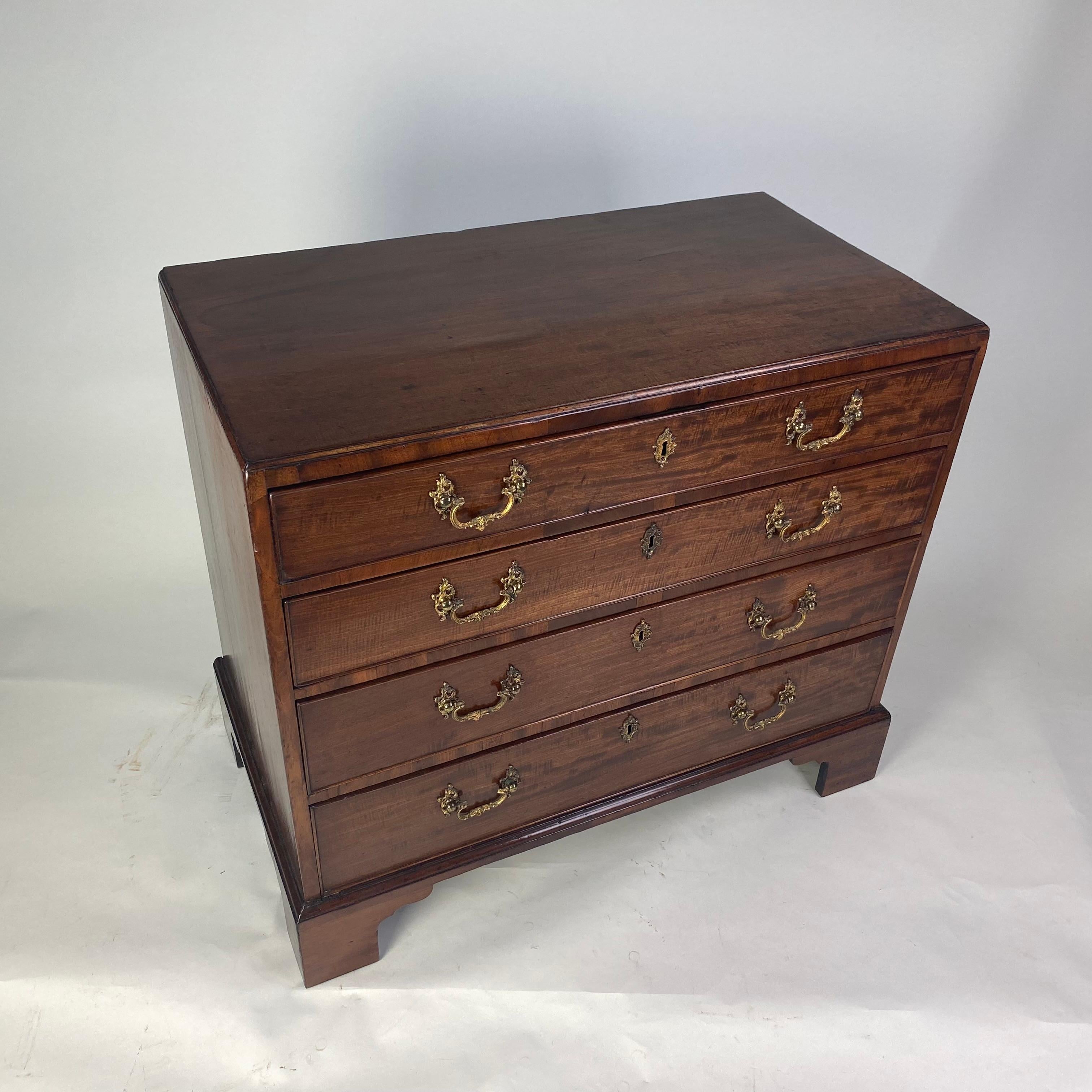 A fine quality late 18th century chest of drawers of small size, with moulded edge caddy-top abouve four long graduated drawers, the top of which is fully filtted with various lidded and open compartments for dressing acoutrements. Standing on
