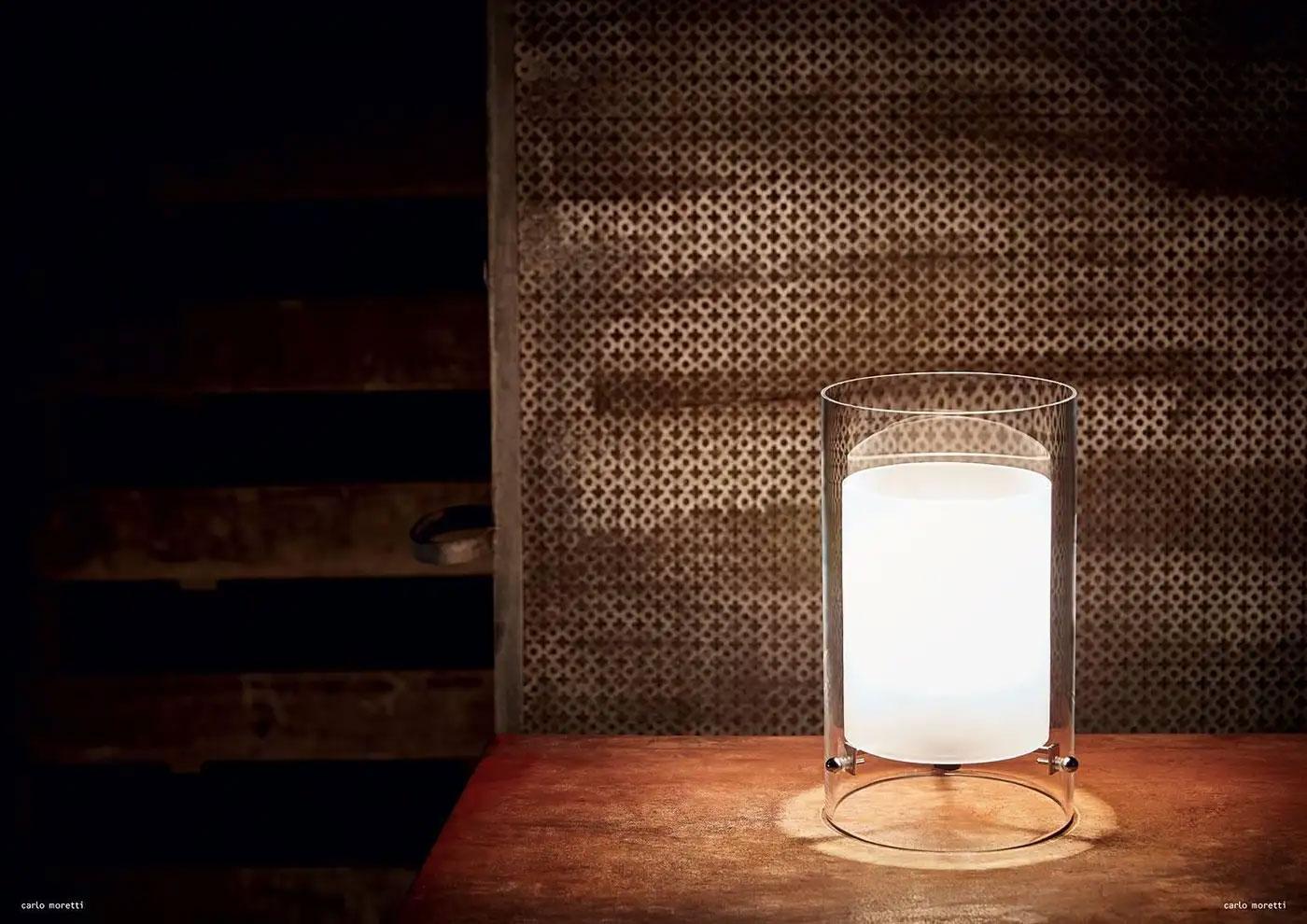 Lampe de table en verre clair soufflé à la bouche de Murano avec fixation en laiton chromé et cylindres en verre transparent et opalin. La lampe a été conçue en 1993 par Carlo Moretti.

Ampoule à incandescence de 60 watts, douille écolamp de 42