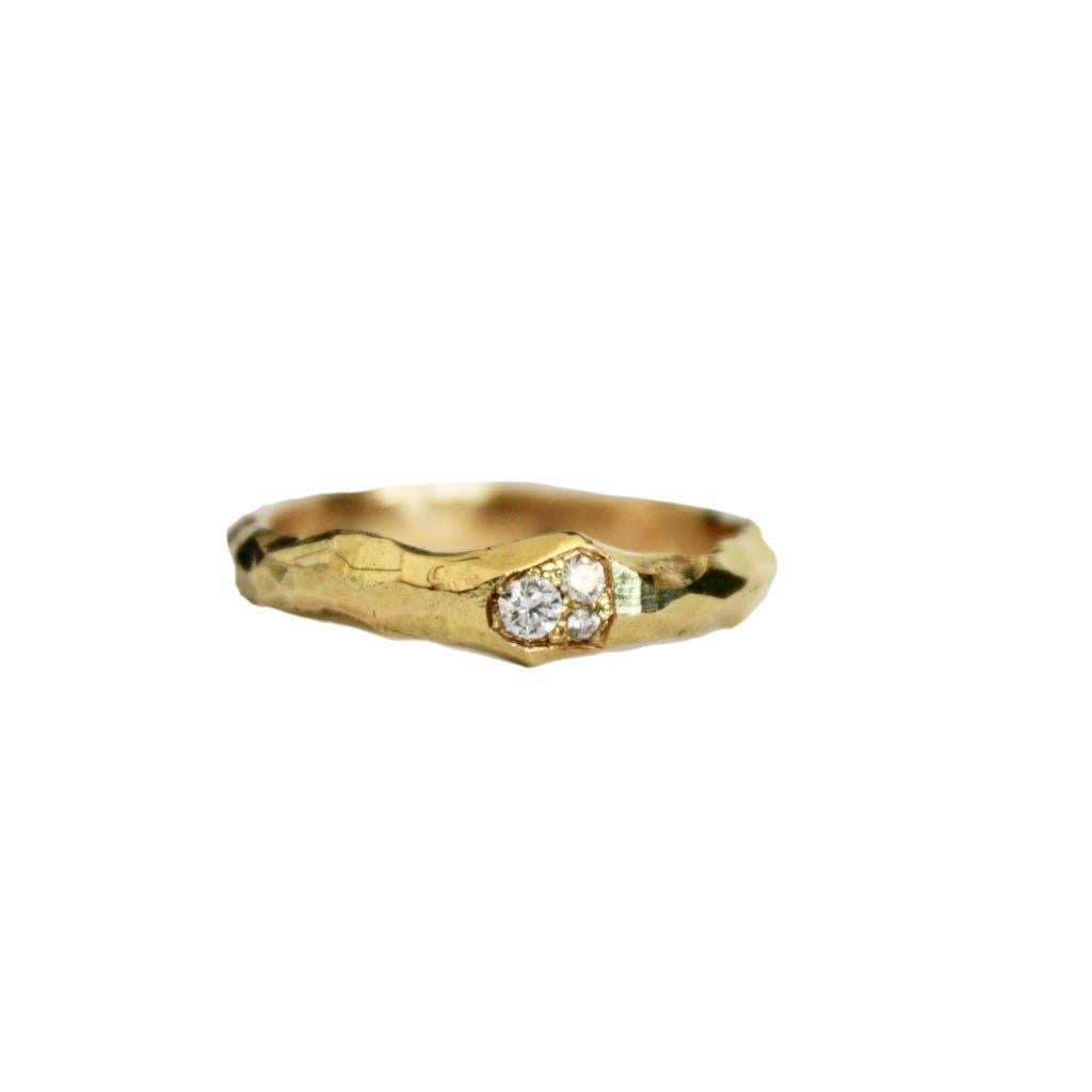 This hand carved band has 3 set diamonds clustered within 18 karat gold. This piece is 3.5mm wide and 2mm thick. Textured and hand finished throughout, this piece holds so much intrigue and is a wonderful upgrade to the simple gold band. Diamonds