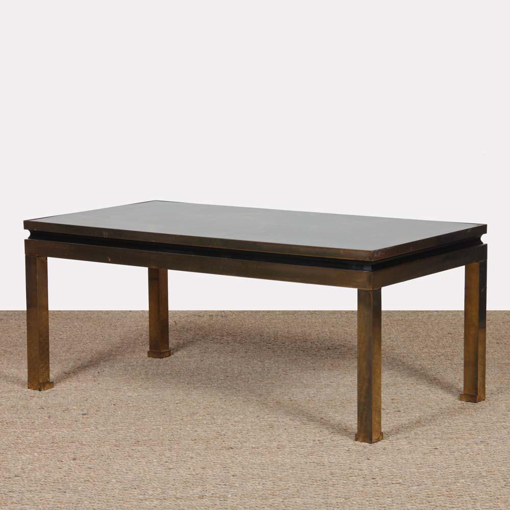 This coffee table was designed by Guy Lefevre for Maison Jansen. The structure is in brass and the top in laminate. This piece is in good vintage condition. The metal has a beautiful patina.