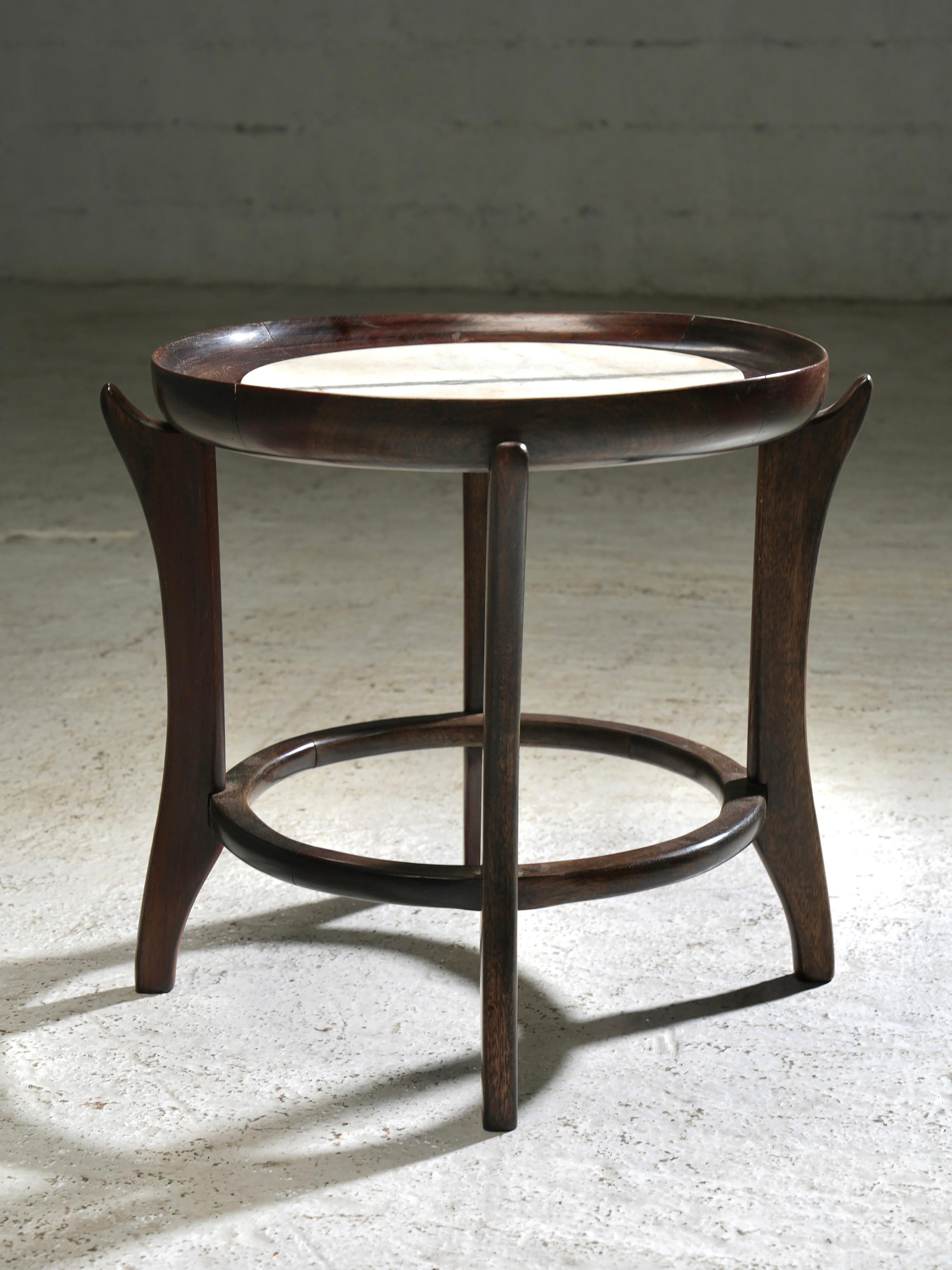 Tavolino da caffè di Scapinelli, Brasile, anni '50

Questo tavolino scultoreo di Giuseppe Scapinelli presenta una struttura organica in legno scuro con gambe elegantemente ricurve e un bordo rialzato. Il piano rotondo contiene una lastra di marmo