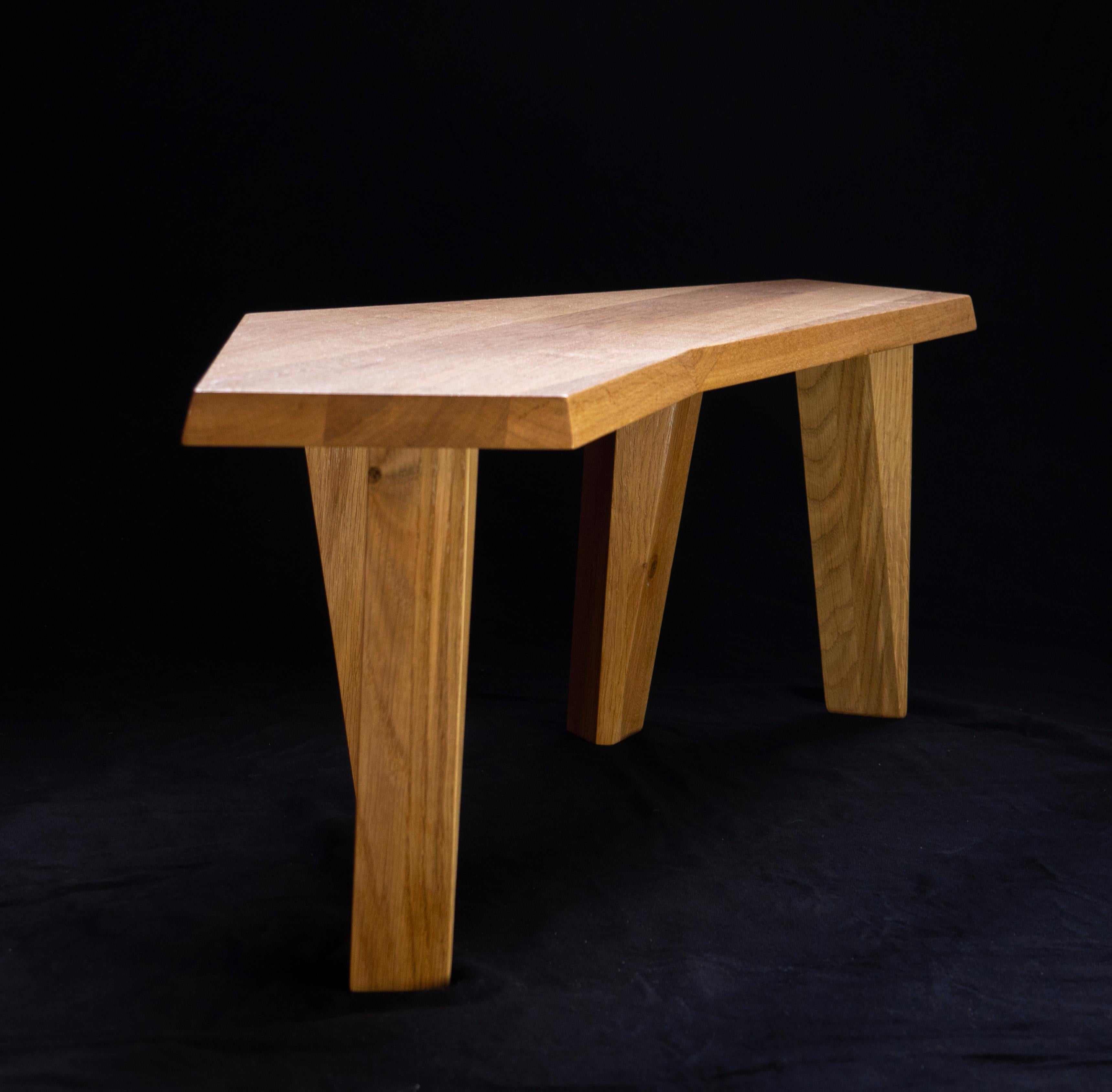 Small coffee table in oak that can double as a bench. This sculptural piece by Jacques Jarrige feels animated by the hand of the artist. The jagged top is supported by four asymmetrical legs.