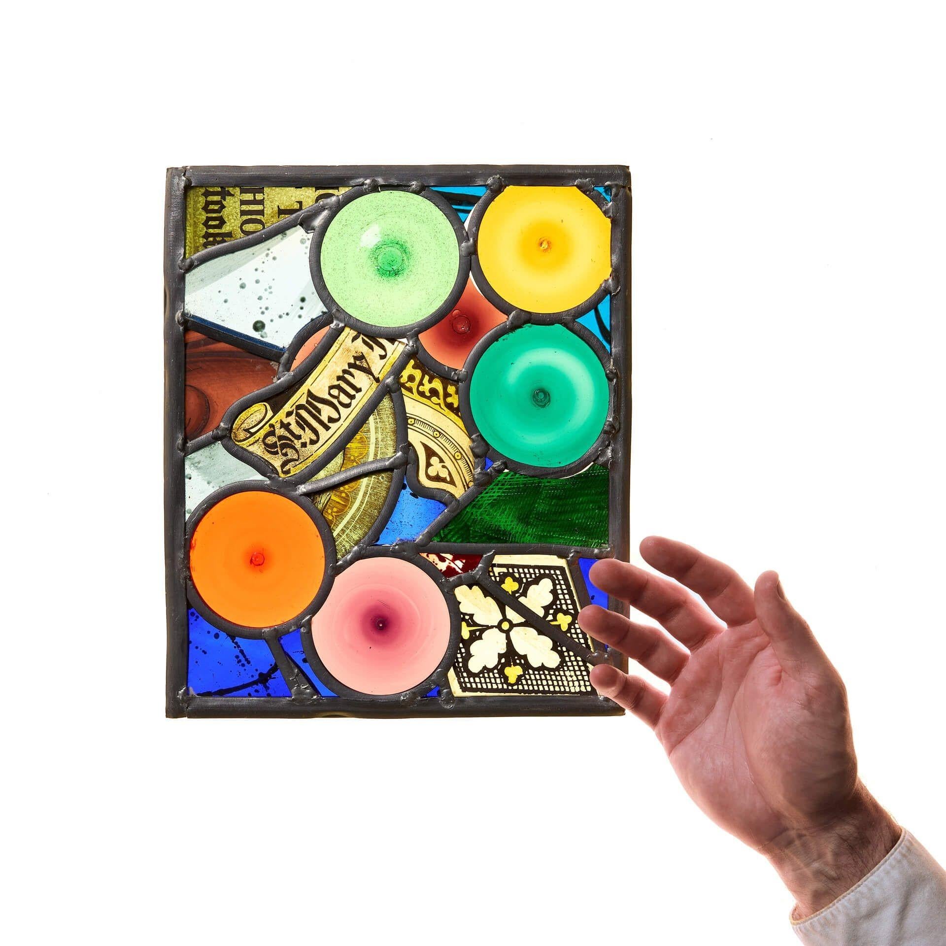 Un petit panneau de vitrail unique et merveilleusement coloré. Bien qu'il ait été réalisé au milieu du XXe siècle, ce vitrail utilise du verre provenant de différentes périodes antérieures, notamment des rondeaux et des fragments ecclésiastiques.