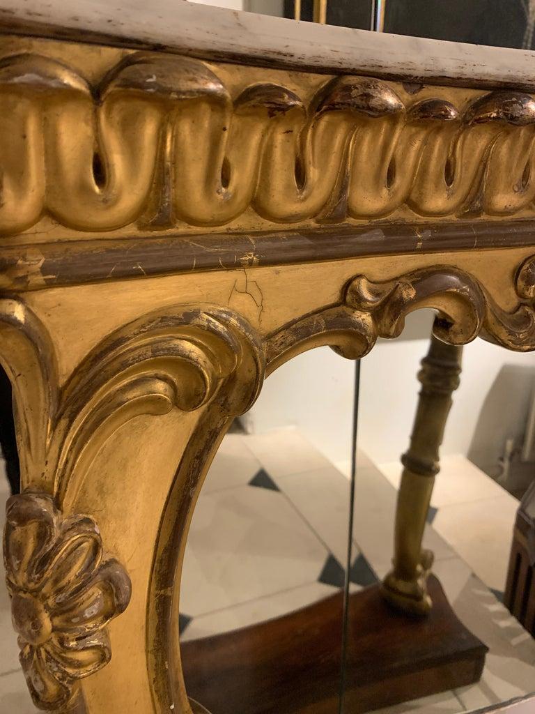 Small console table with a white marble top and sitting on a mahogany base. Bowed gilt legs and carved details to legs and relief,
circa 1880.