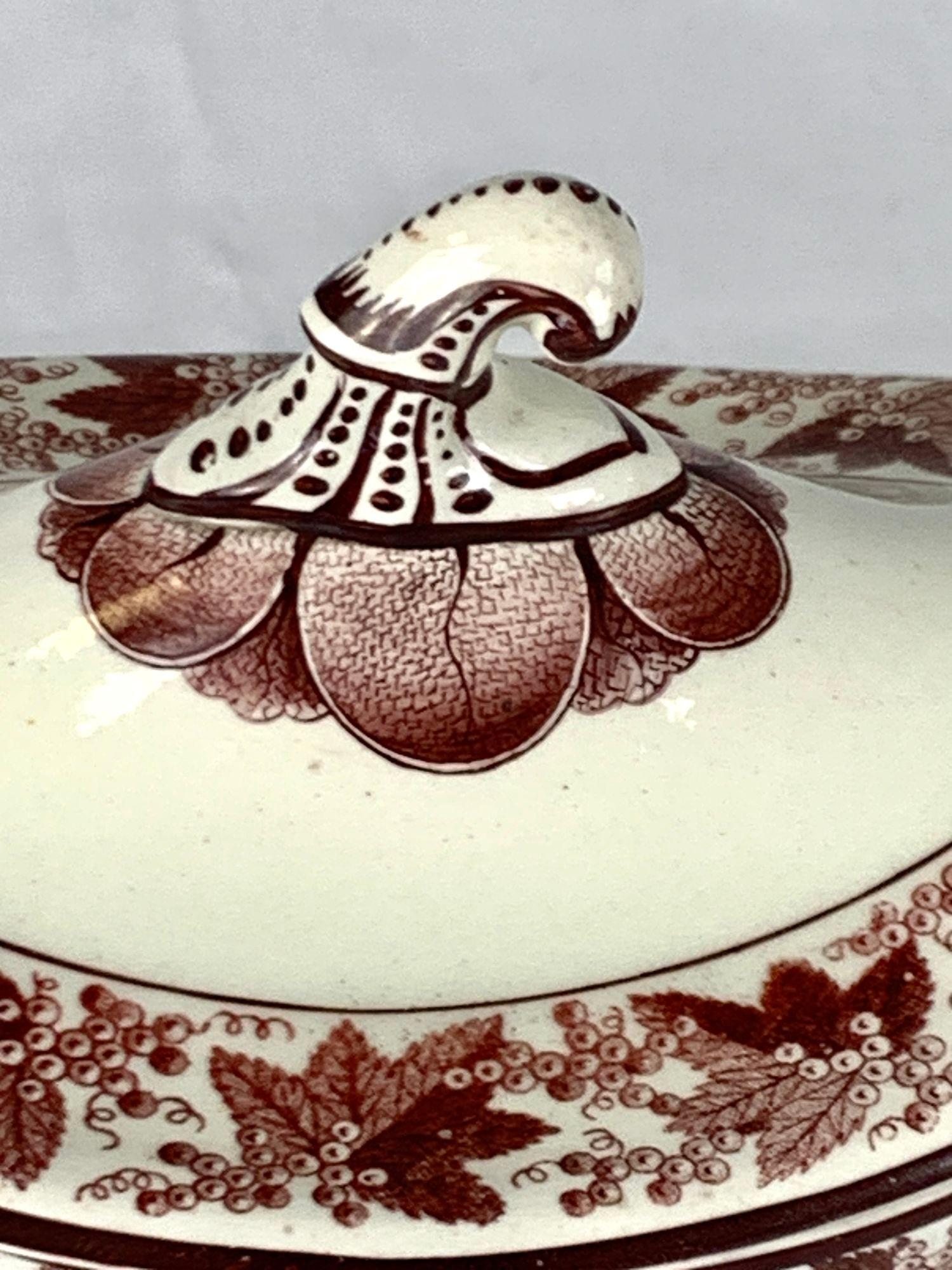 Cette charmante petite soupière en faïence présente le motif 