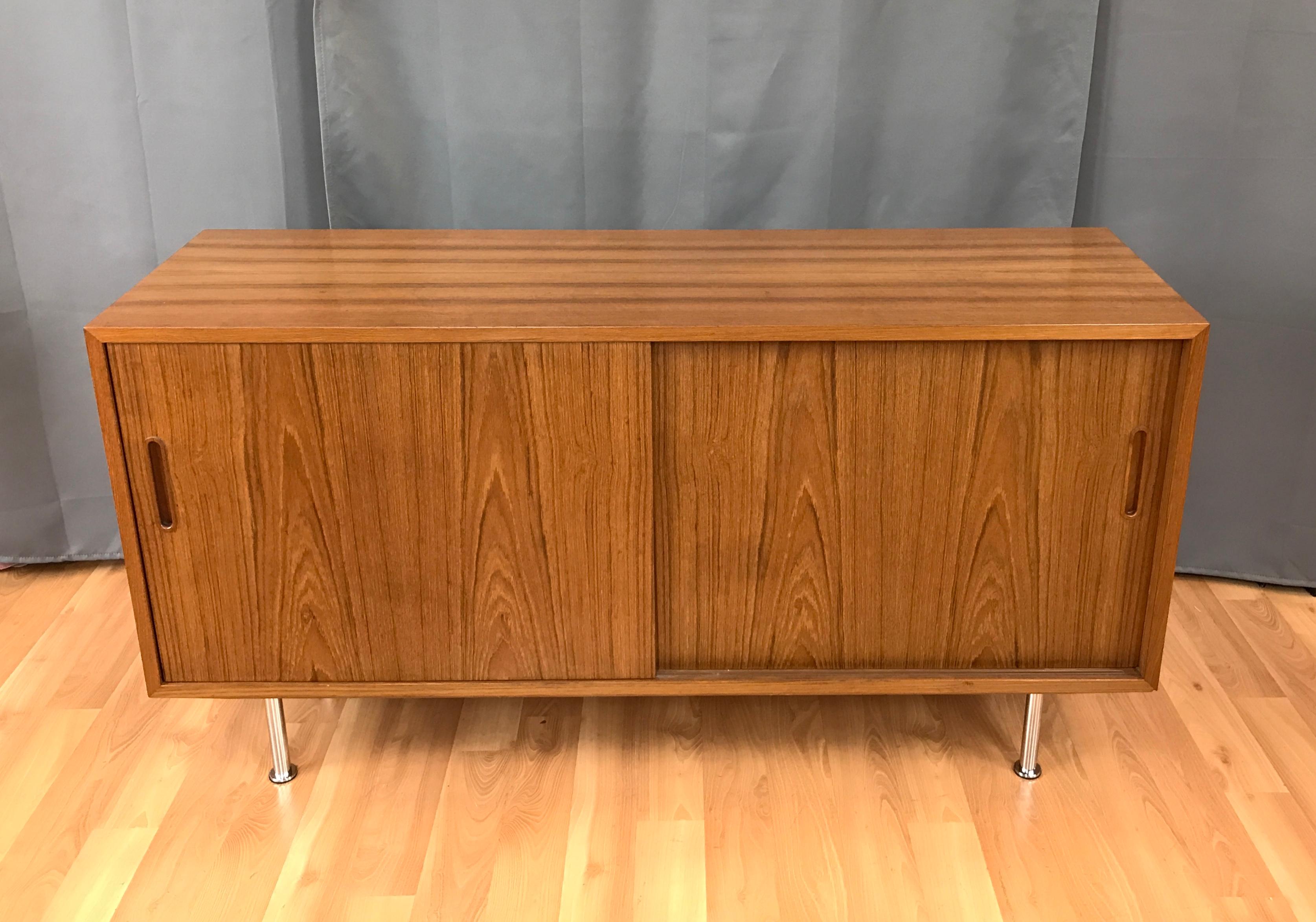 Small credenza or sideboard in Teak by Paul Hundevad, circa 1960s. Has two sliding front doors, behind them on the right are two adjustable shelves, and on your left one adjustable shelf with a small drawer above. Inside are Beech, the unit sits on