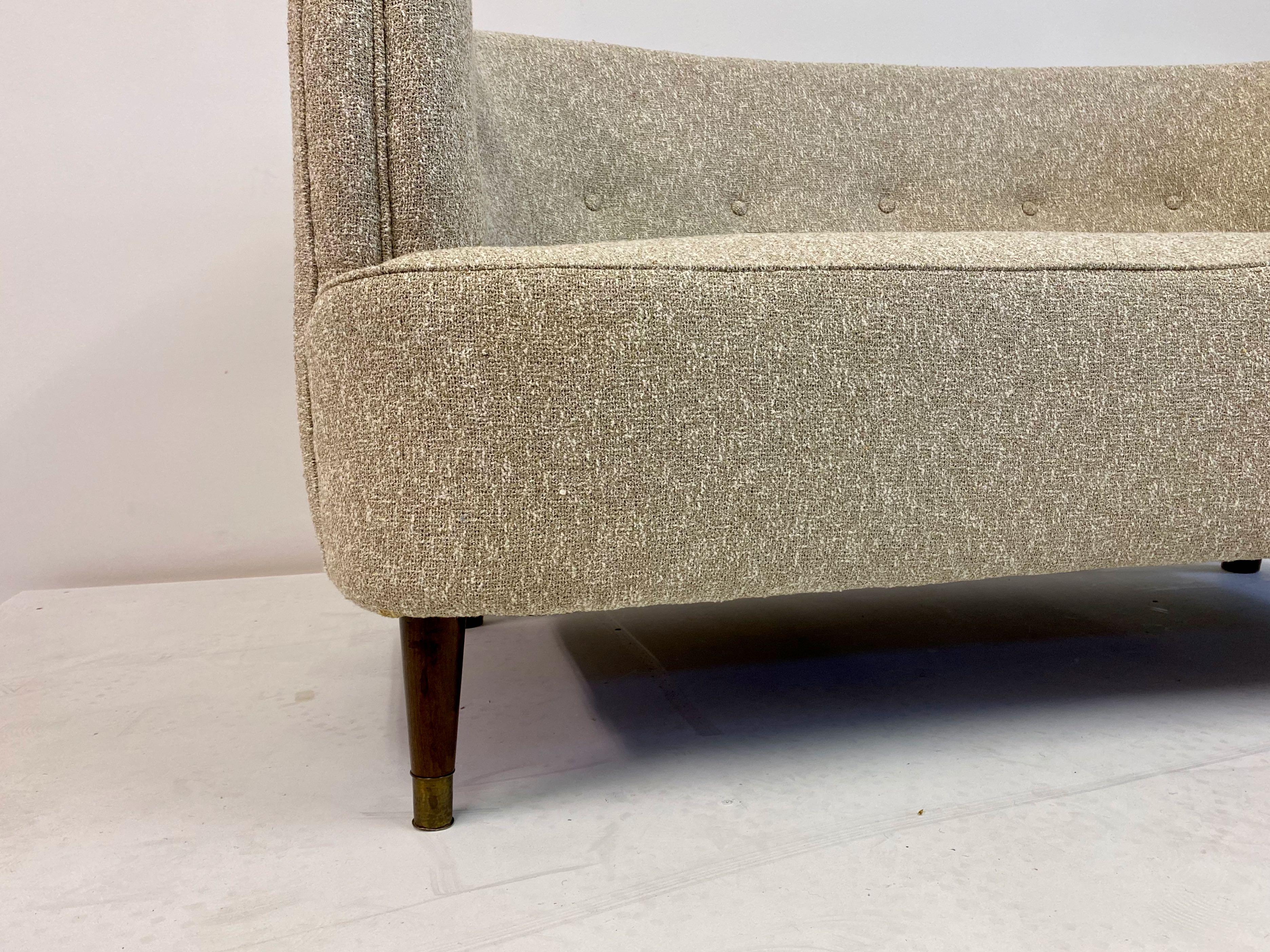 Two-seat sofa

Newly upholstered in Lelièvre Granito Nacre fabric

Tub shaped

Stained beech legs

Brass feet

Danish 1940s.