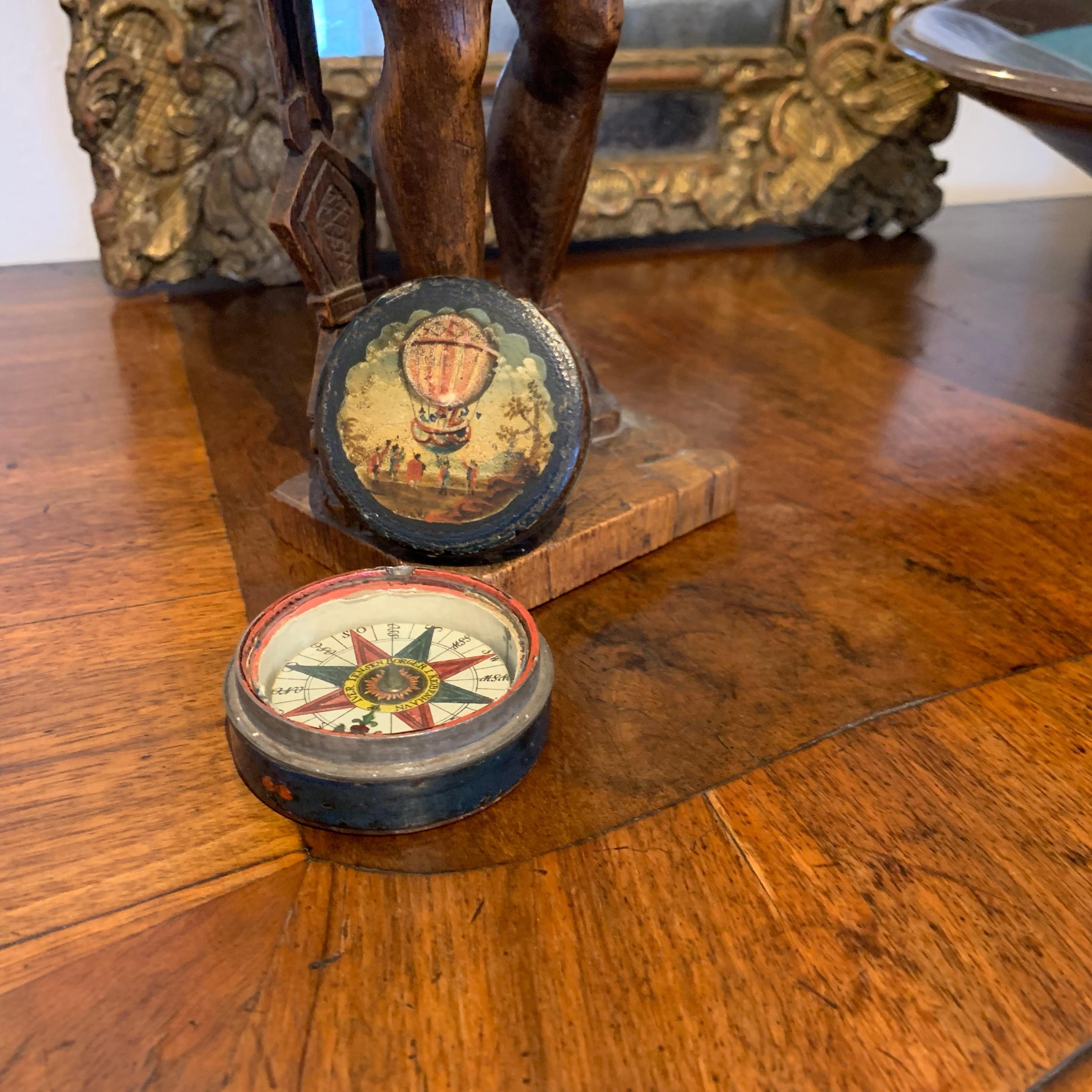 Small 18th century pocket compass with hot-air balloon decoration, Copenhagen, Denmark.
The lid is decoration with 5-6 people waving adieu to 3-4 people launching a hot air balloon.