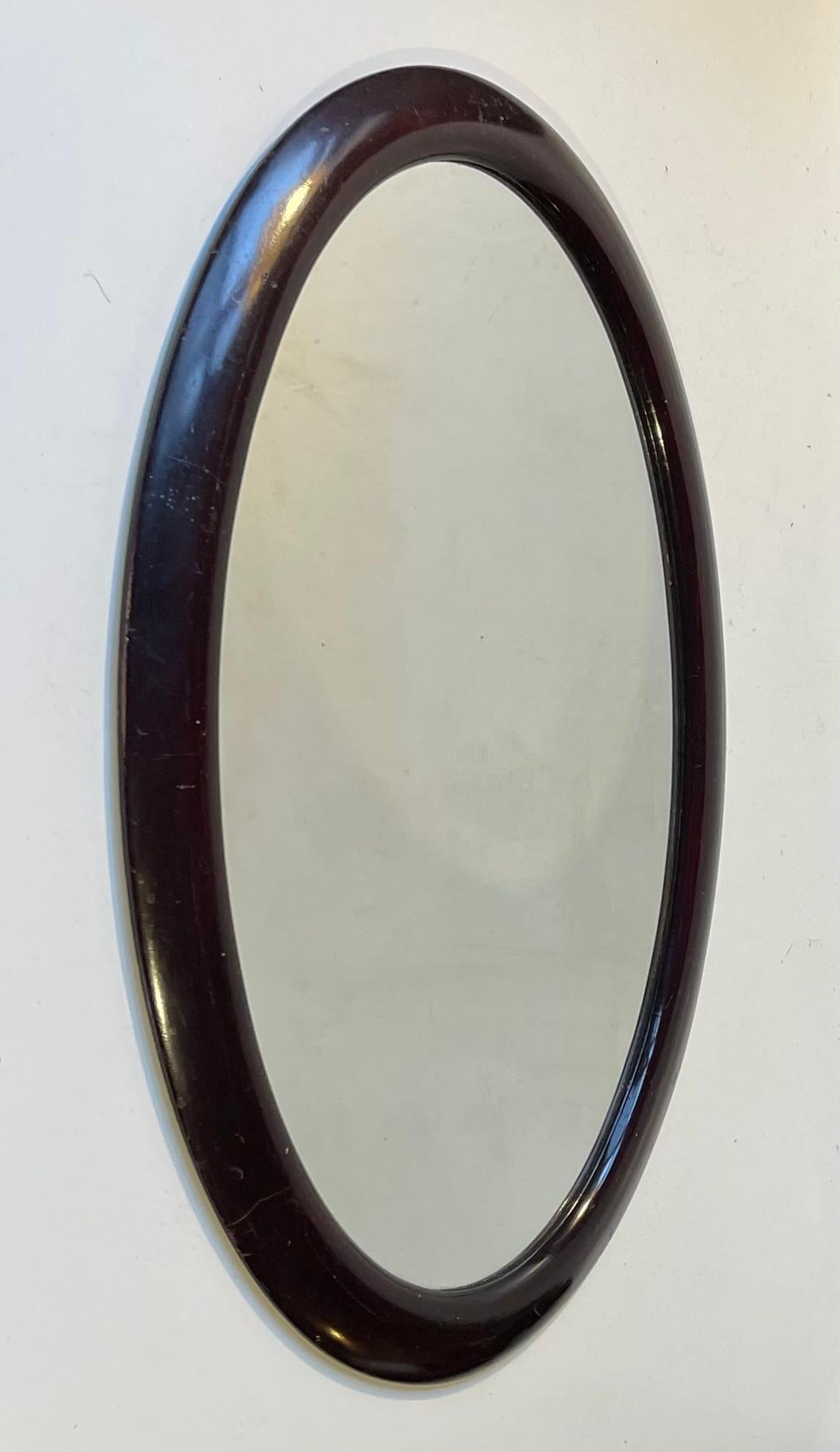 A bend-wood wall mirror in stained oak (dark mahogany tone). Clean curves and simple lines in an oval shape. Made by a Danish cabinetmaker during the early 1920s. 

Measurements: 49x33x3 cm in framed.