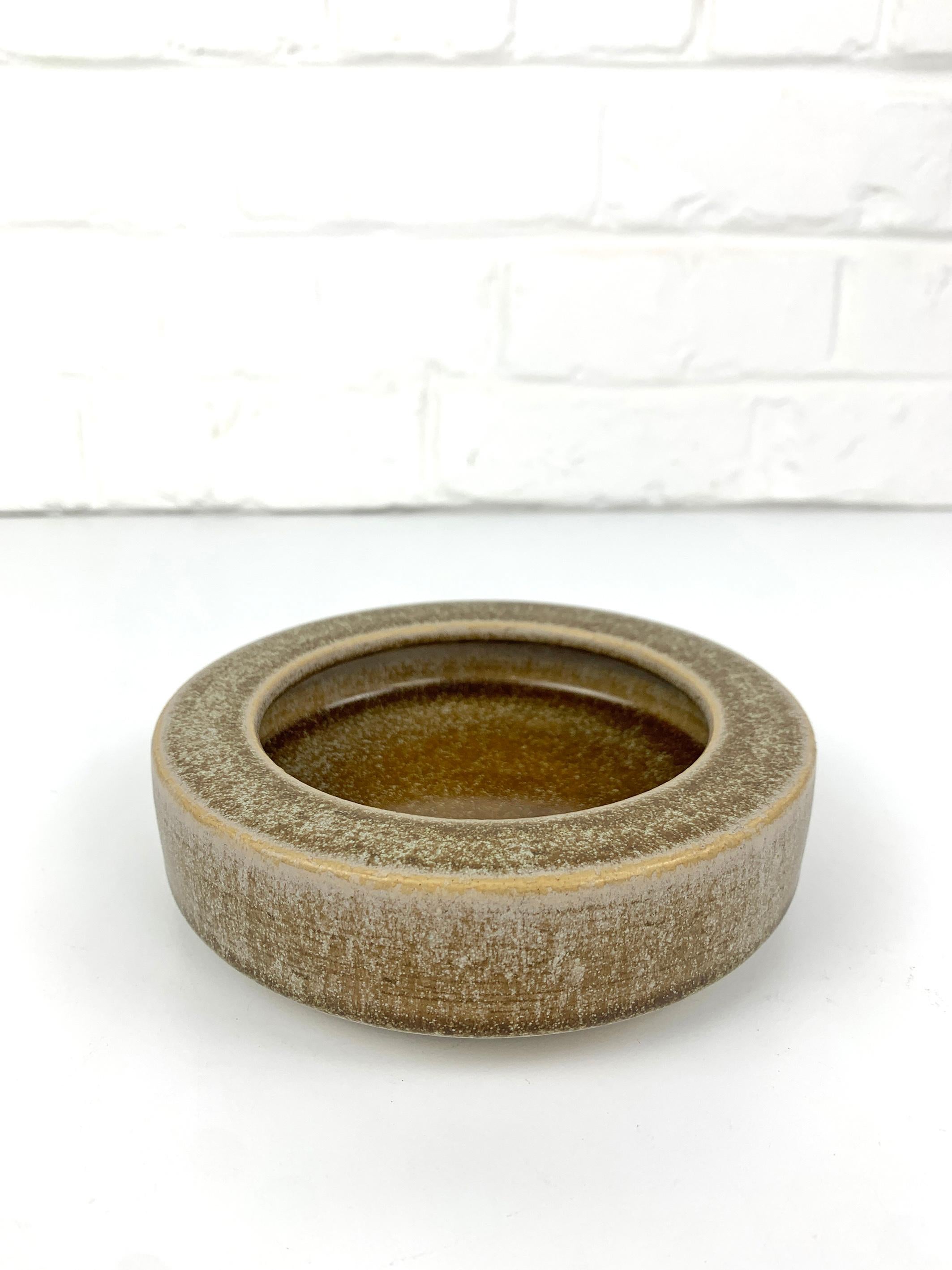 Round ceramic vide-poche or low bowl in beige-brown earth tones. 

Scandinavian Mid-Century 1960s, produced by Palshus (Denmark), founded by Per and his wife Annelise Linnemann-Schmidt. 

The couple created and produced chamotte (danish clay)