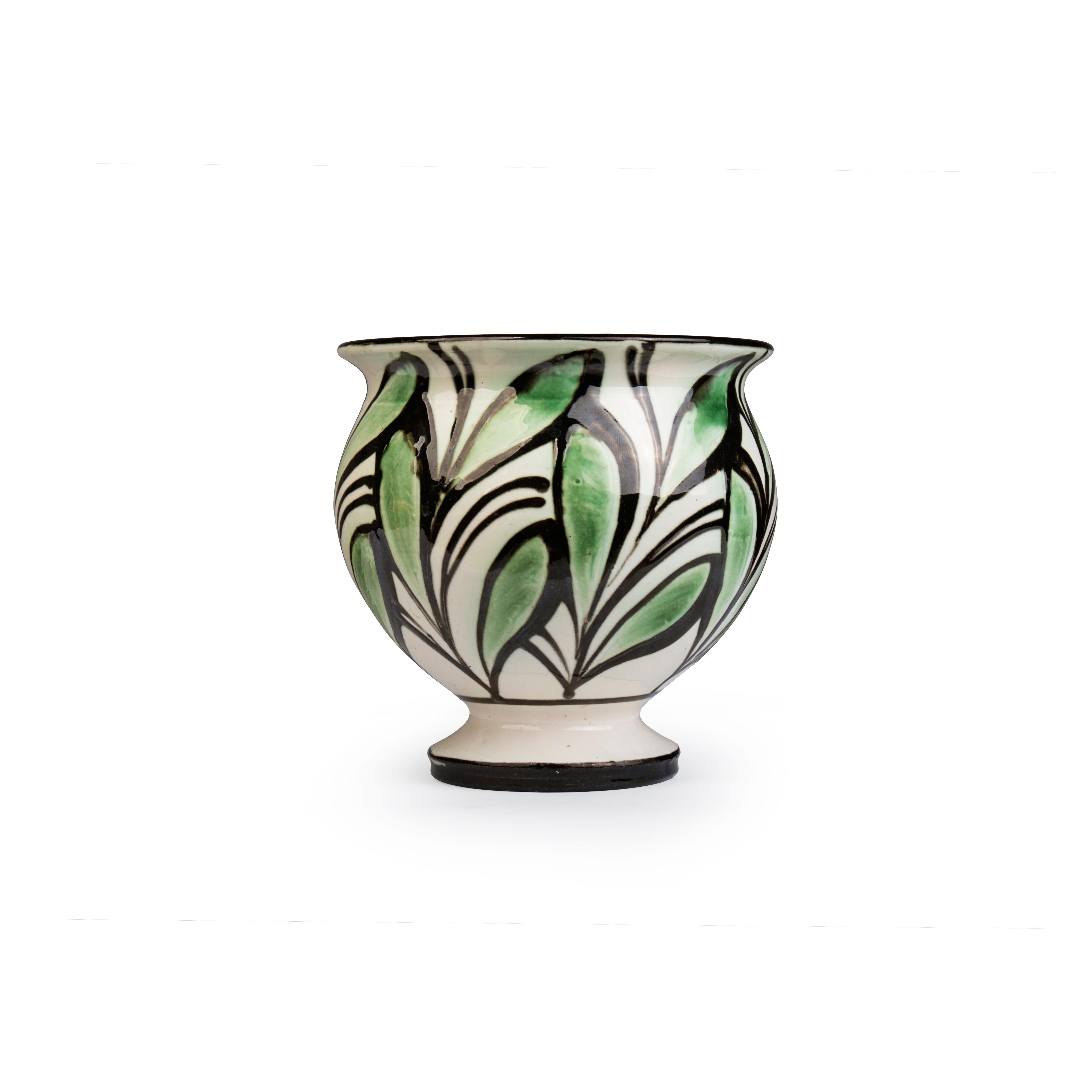 Ce petit vase en faïence de Herman A. Kähler est décoré à la corne de feuilles vertes sur une base blanche. Exécuté par Herman A. Kähler, Danemark, vers les années 1940

Lorsque Herman H. C. Kähler a repris l'entreprise familiale en 1917, en tant