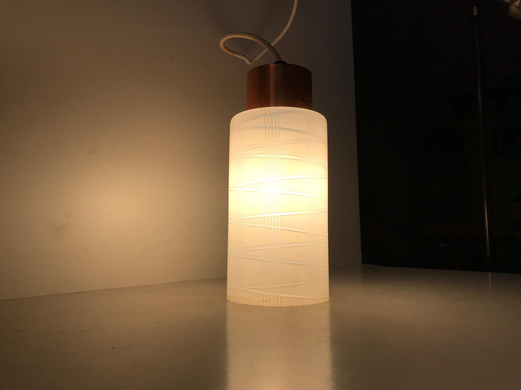 - Small cylindrical striped pendant lamp
- Made from partially frosted hand blown single layered glass
- The top is made from solid copper
- Manufactured by Voss in Denmark during the 1950s.