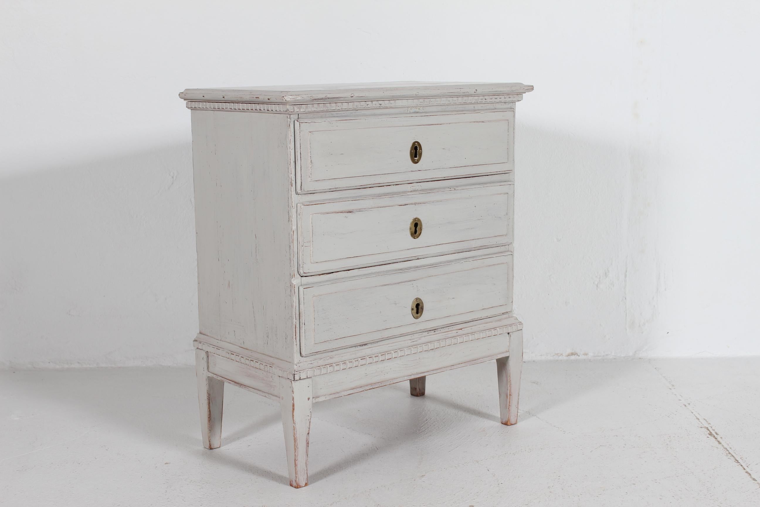 Piccola cassettiera danese in stile Louis Seize realizzata nel 1880 circa in legno massiccio da un abile falegname.
Verniciato a mano di recente con vernice grigia chiara che ora si presenta con una patina. 
La cassettiera è montata con accessori in