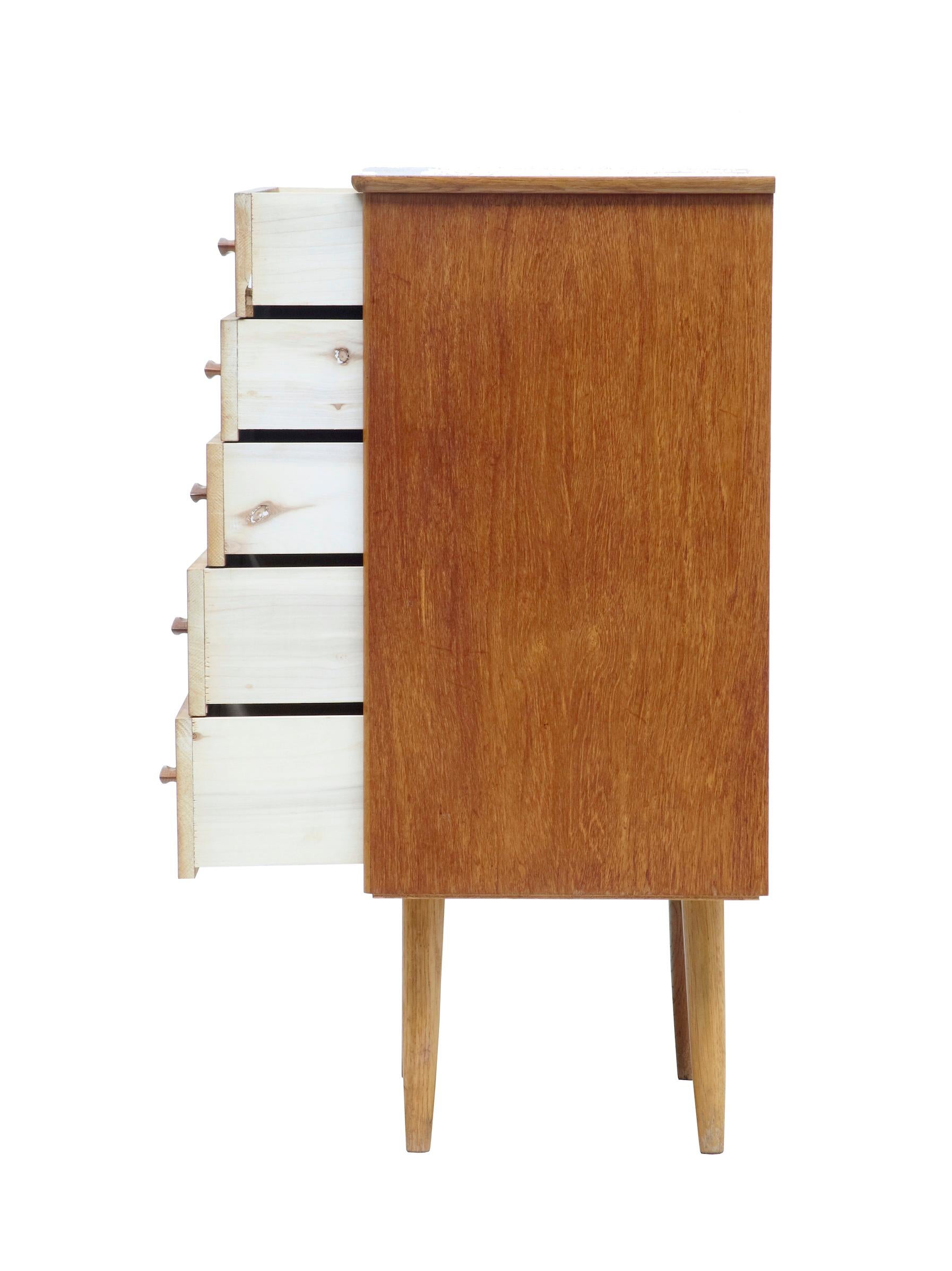 Small Danish mid-20th century teak chest of drawers, circa 1960.

Small 5-drawer chest of drawers. Fitted with contrasting light oak handles.

Light veneer damage to 4th drawer (photographed) surface marks to top surface, which could be improved.