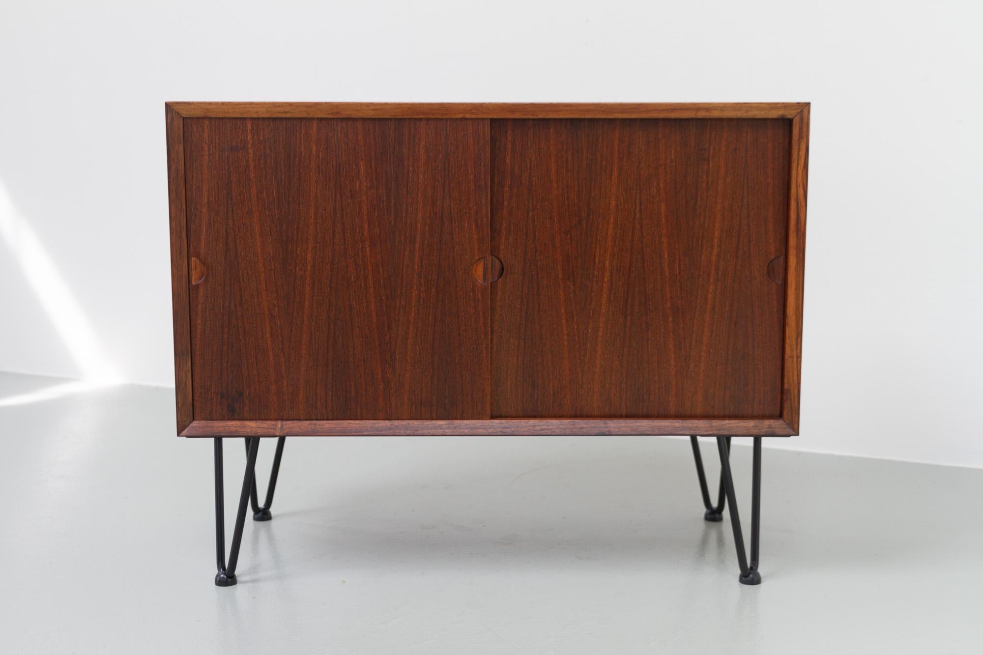 Small Danish Modern Rosewood Sideboard by Poul Cadovius for Cado, Denmark, 1960s.
Vintage Danish Rosewood sideboard with sliding doors and one adjustable shelf inside. Beautiful Rosewood/palisander veneer with expressive grain pattern. Fitted with