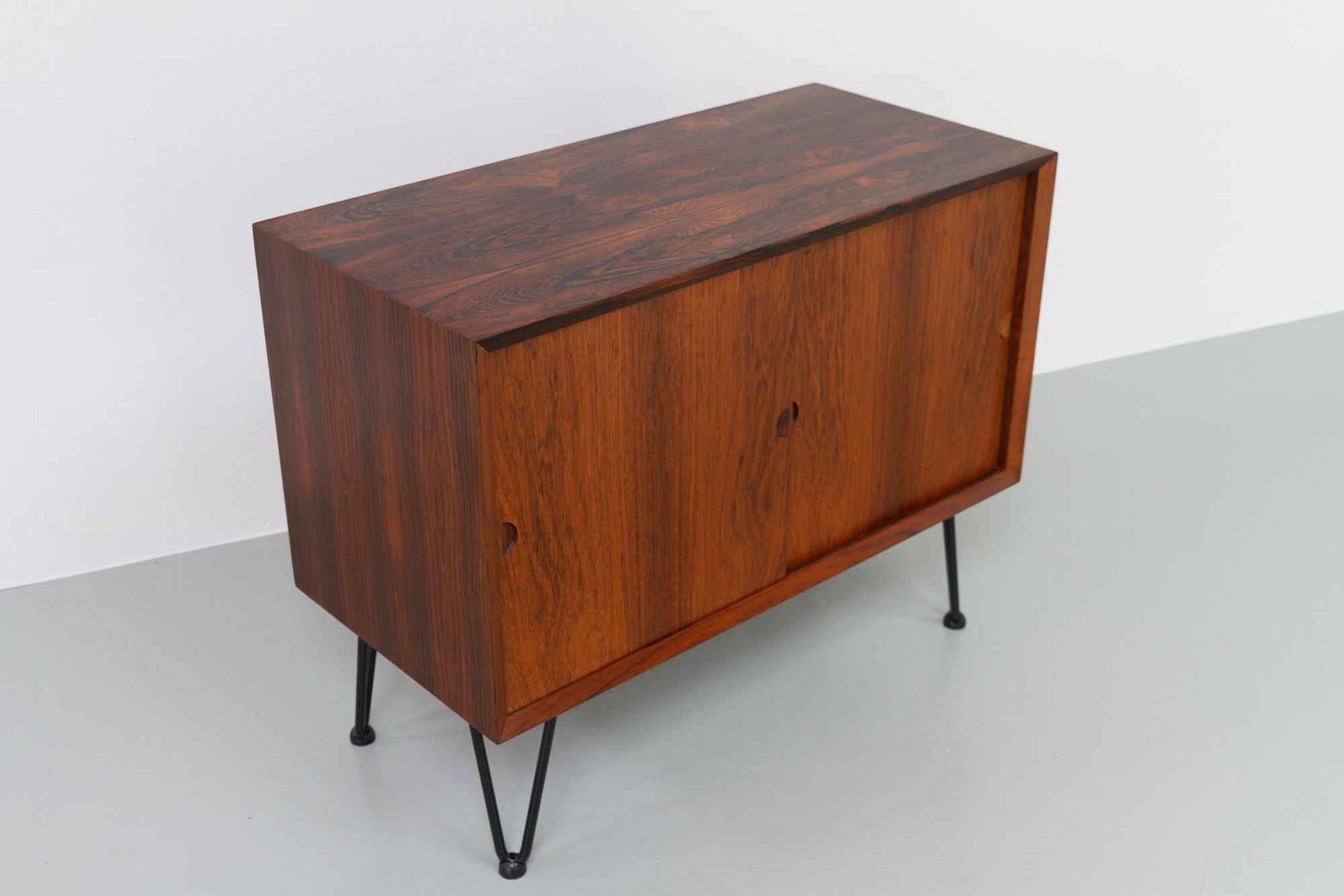 Small Danish Modern Rosewood Sideboard by Poul Cadovius for Cado, Denmark, 1960s.
Vintage Danish Rosewood sideboard with sliding doors and one adjustable shelf inside. Stunning Rosewood/palisander veneer with expressive grain pattern on top. Fitted
